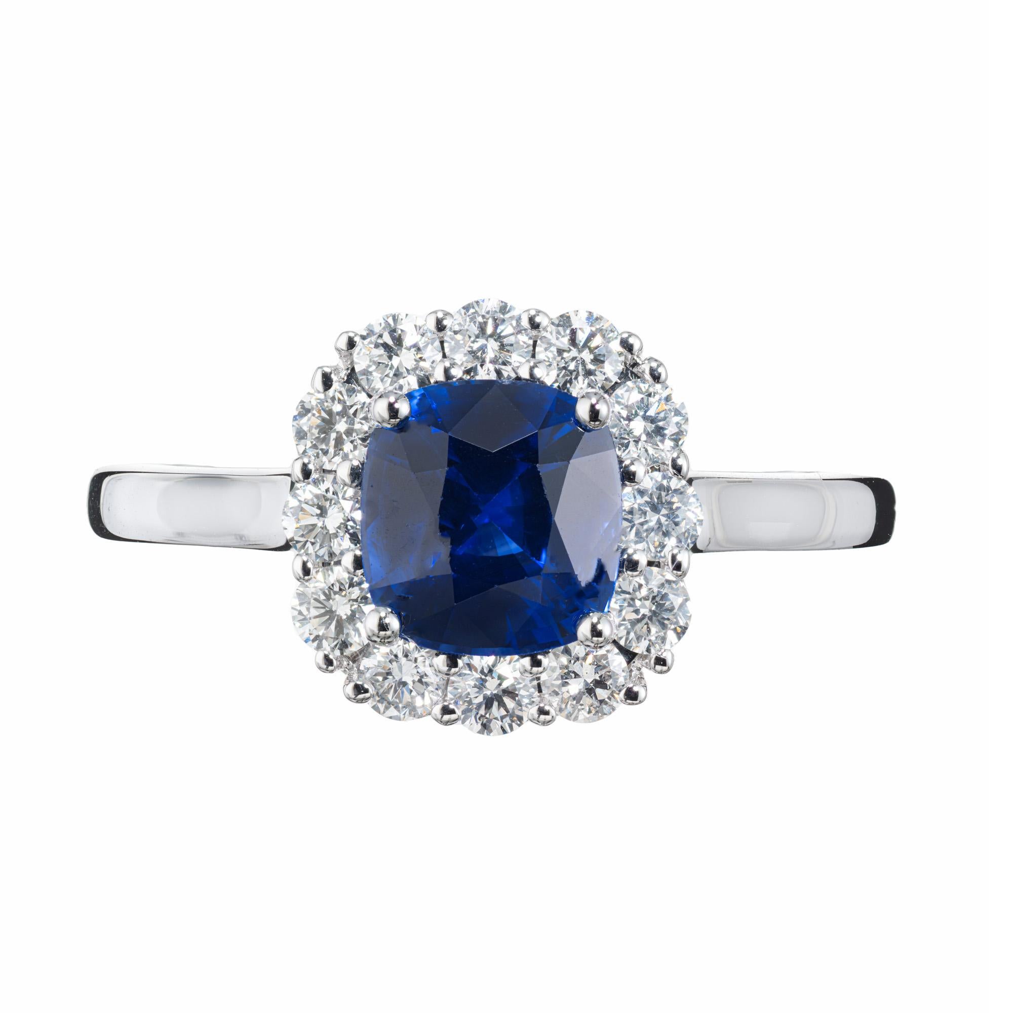 Sapphire Diamond Halo Gold Engagement Ring. Crafted with precision and elegance, the center stone is a stunning 1.33 carat GIA certified cushion cut sapphire that radiates with a deep rich blue. Surrounded by a halo of 12 sparkling round brilliant