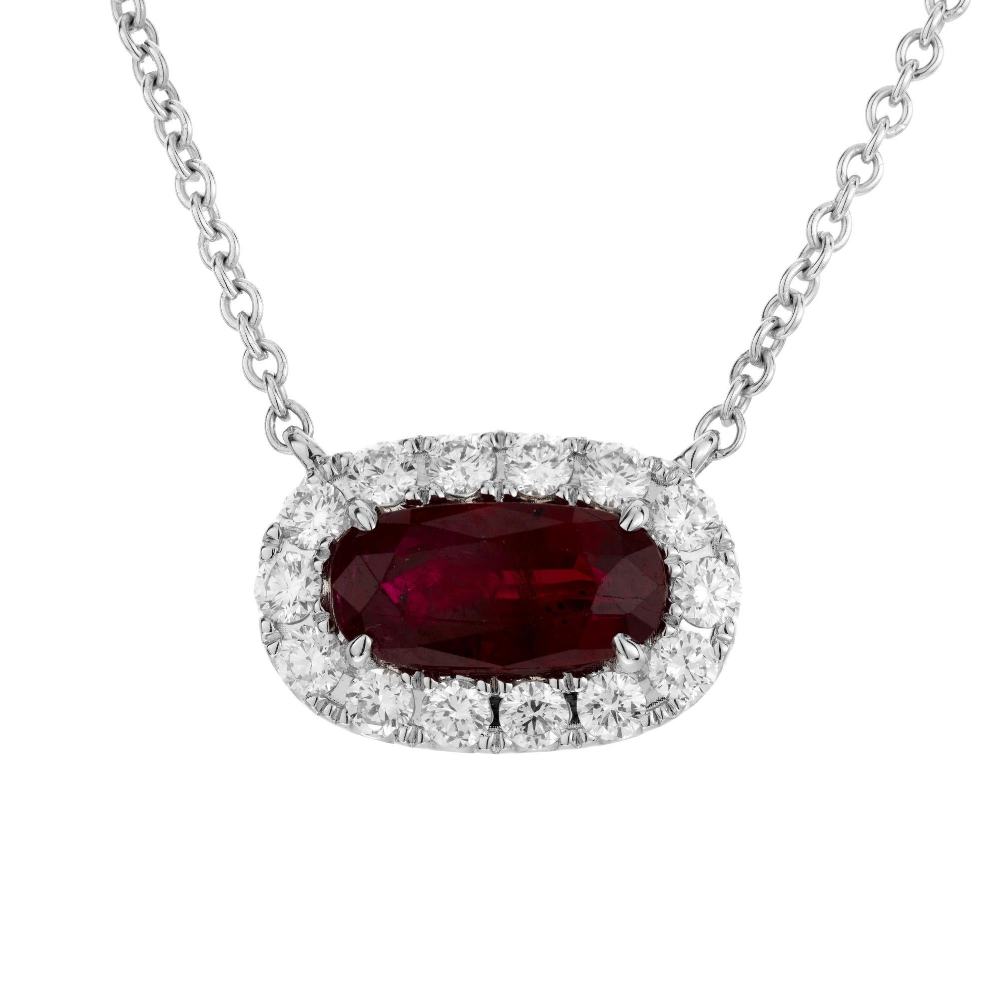 This stunning piece features a vibrant 1.35 carat oval ruby. The ruby is expertly set sideways in the pendant and is adorned with a halo of 14 round brilliant cut diamonds. The GIA has certified the ruby as simple heat only. The chain is 18k white