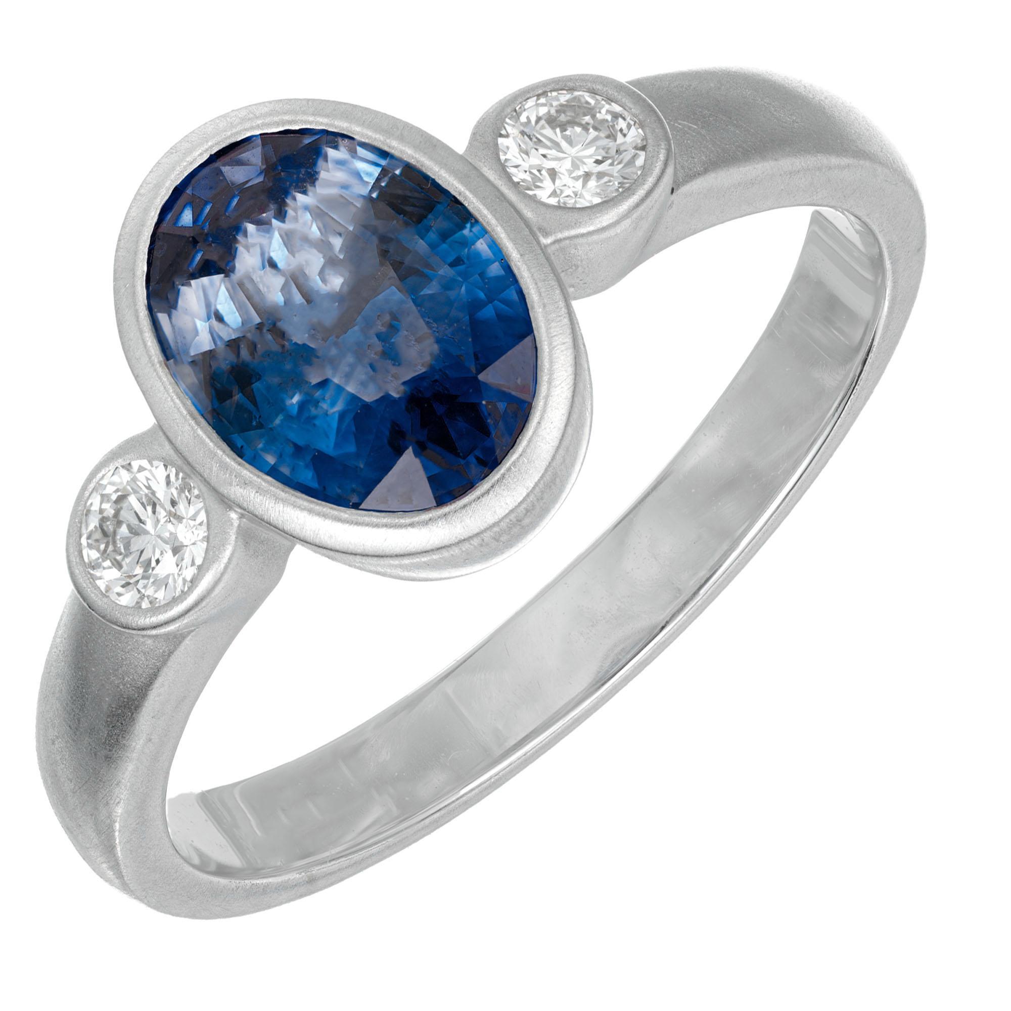 Sapphire and diamond three stone engagement ring. GIA certified center oval sapphire in a 14k white brushed gold setting with 2 round accent diamonds. GIA certified natural simple heat only  Ceylon sapphire. Designed and crafted in the Peter Suchy