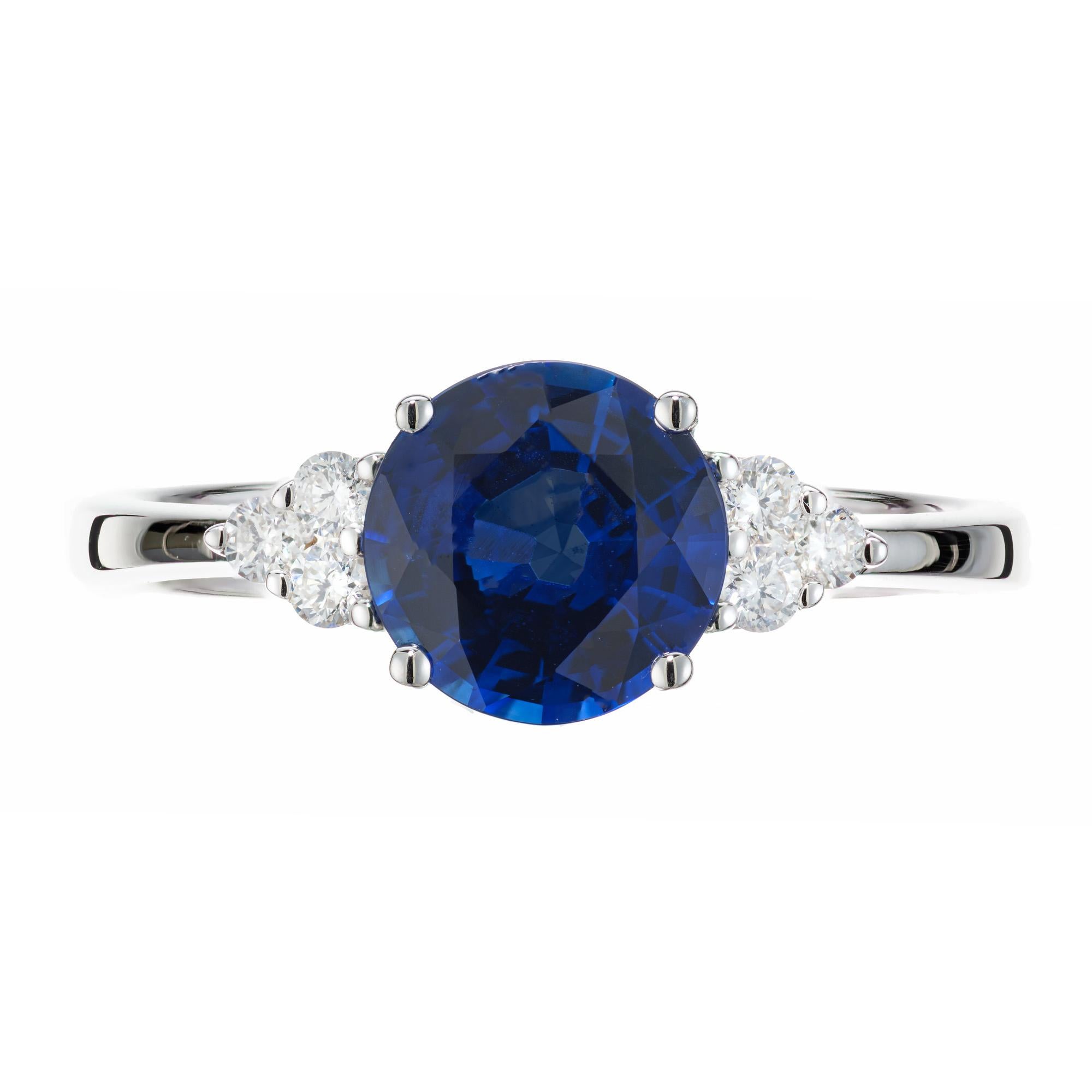 Sapphire and diamond engagement ring. GIA certified round rich warm blue 1.49ct center stone set in a 18k white gold setting with 3 round near colorless diamonds on each side of the sapphire. This simple and classic design was created in the Peter