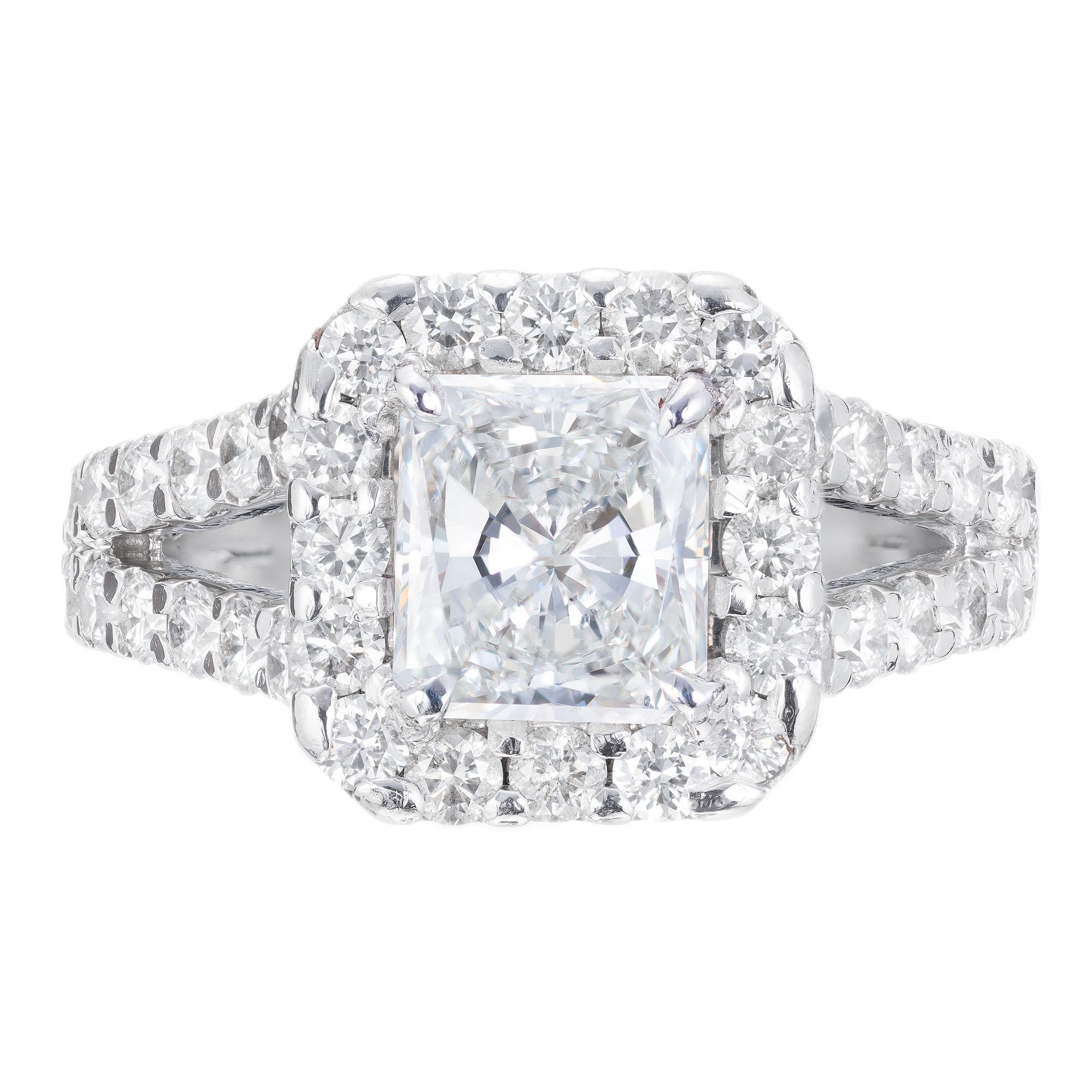 1.53 carat radiant cut diamond engagement ring. GIA certified center stone in a platinum diamond halo setting with 40 round brilliant cut accent diamonds. Created in the Peter Suchy Workshop.  

1 rectangular modified brilliant cut diamond F-G VS2,