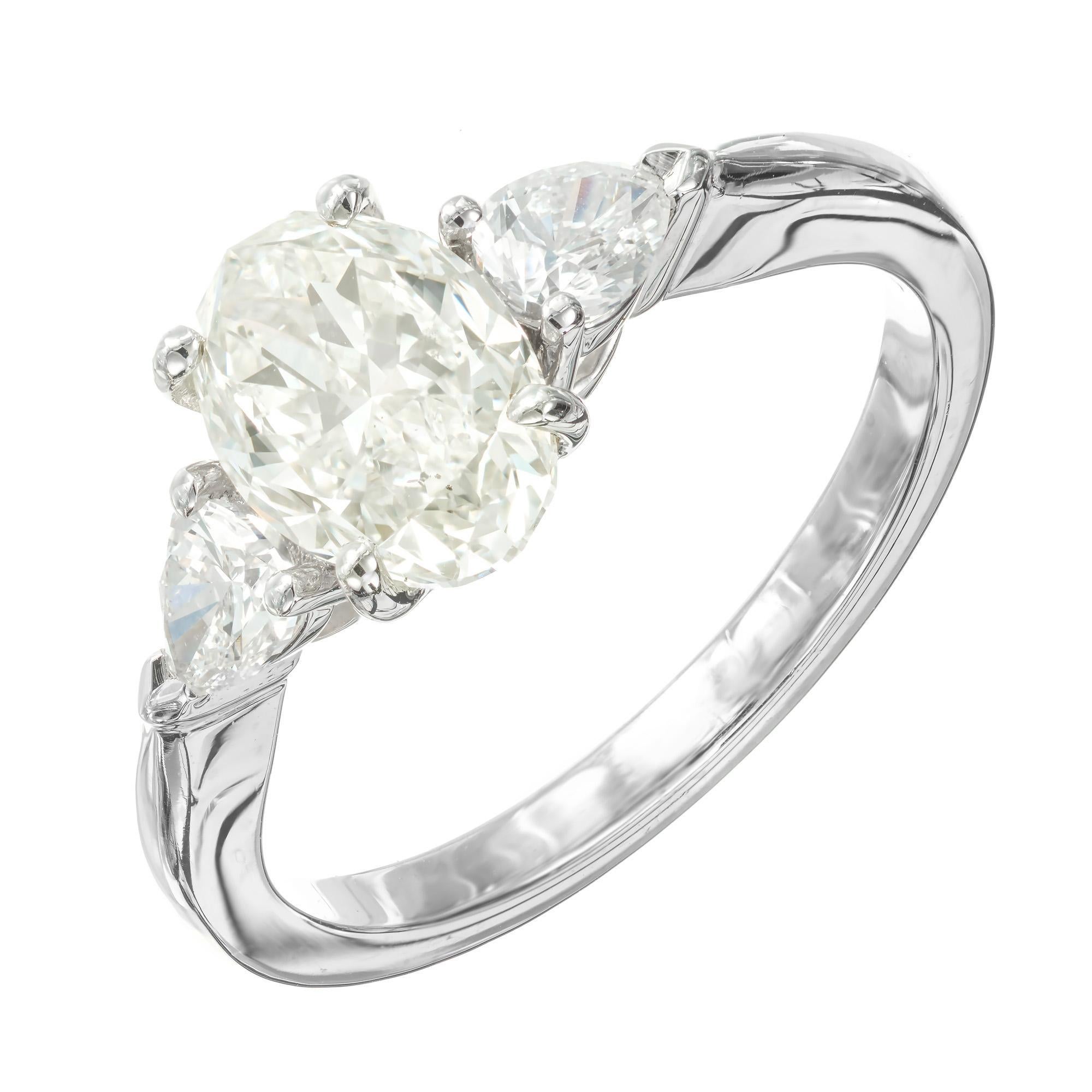 Bague de fiançailles en diamant. Diamant central ovale de 1,60 carat certifié par le GIA, de couleur blanche avec juste un soupçon de couleur, serti dans une monture en platine avec 2 diamants latéraux en forme de poire. Conçu et fabriqué dans