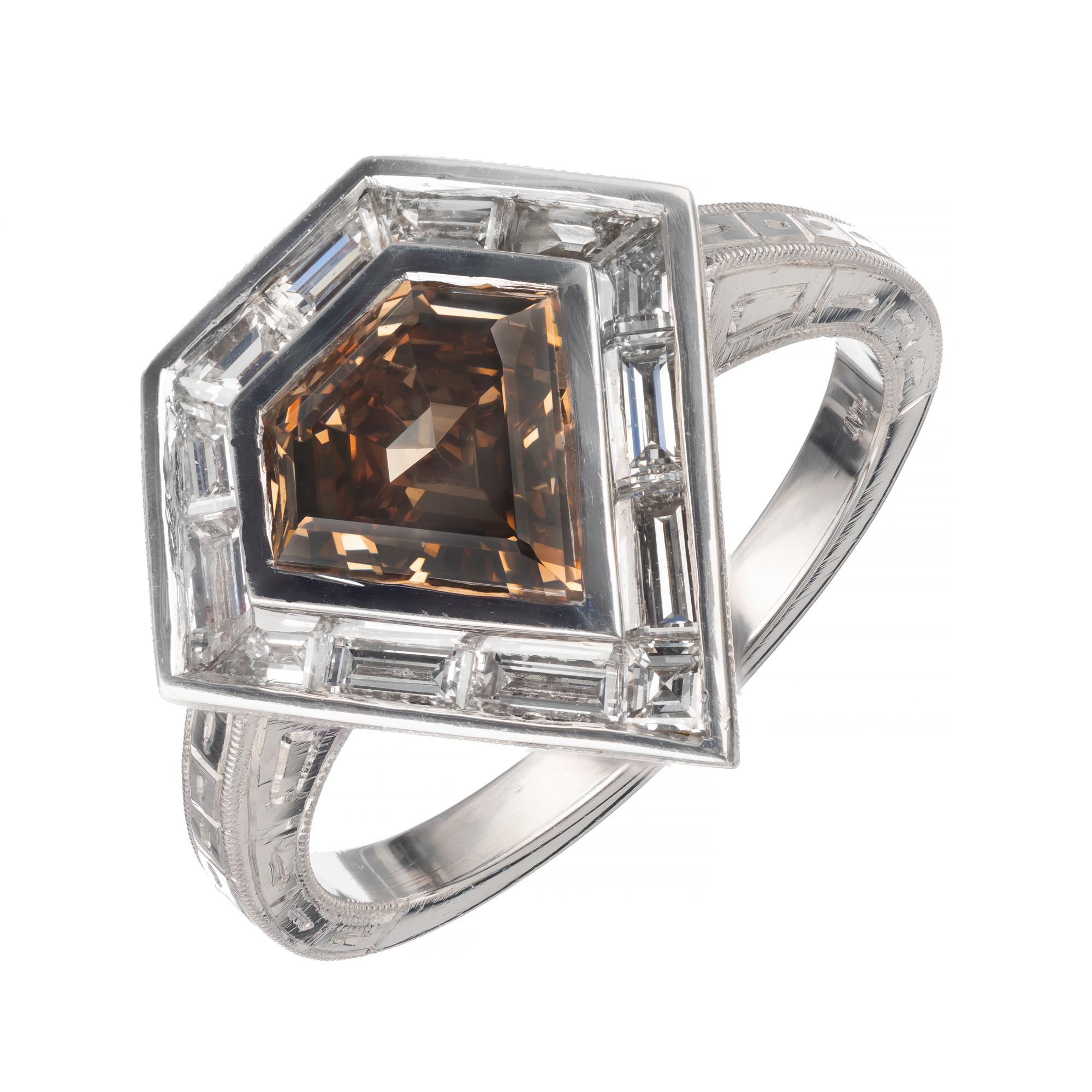 Brown Step cut shield shape diamond and white diamond halo engagement ring. GIA certified natural fancy yellow brown shield shaped center diamond. Set in a platinum setting with thirteen baguette diamonds. Designed in the Peter Suchy Workshop.  

1