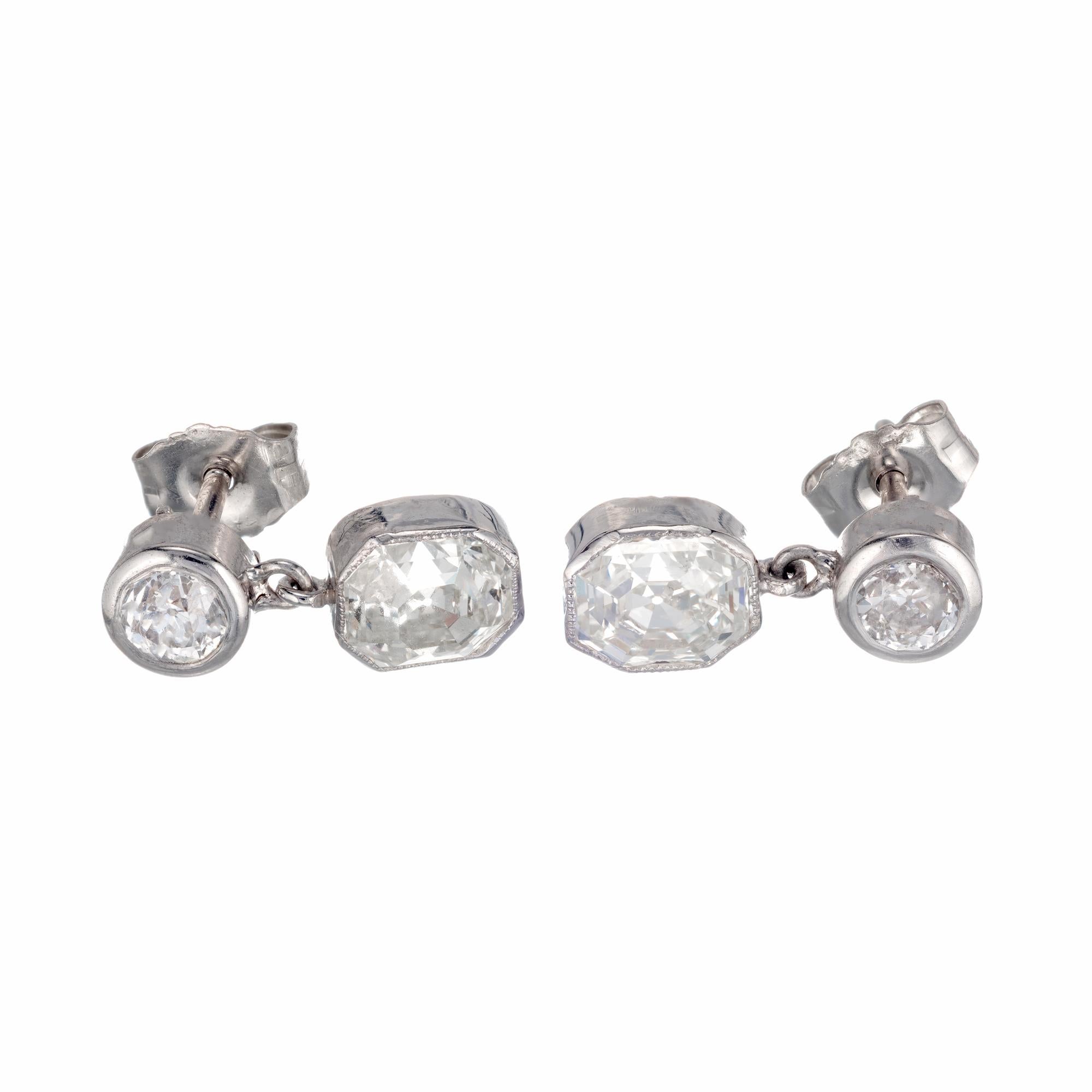Eight-sided step cut diamond dangle earrings. The bottoms are GIA certified octagonal step cut diamonds circa 1915-1920 with sparkle and a hint of warm color face up. The tops are old euro cut diamonds, also circa 1915-1920. set in platinum and