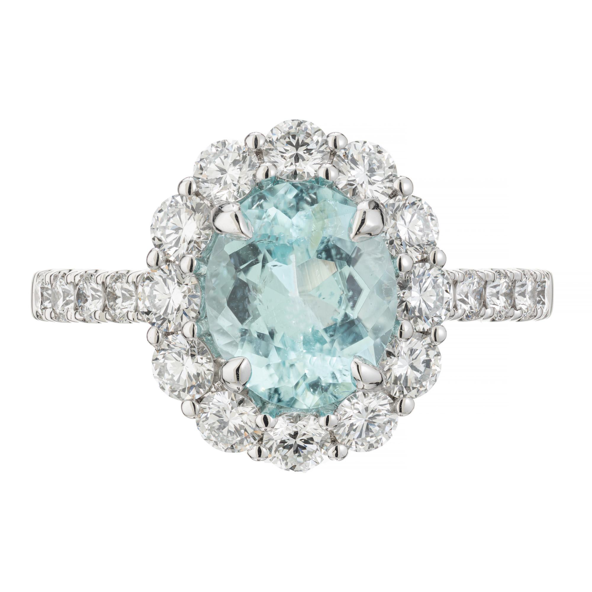Beautiful, bright soft neon blue tourmaline and diamond engagement ring. GIA certified 1.99 carat oval Paraiba Tourmaline center stone. Mounted in a platinum setting with a halo of round brilliant cut diamonds accented with diamonds along both