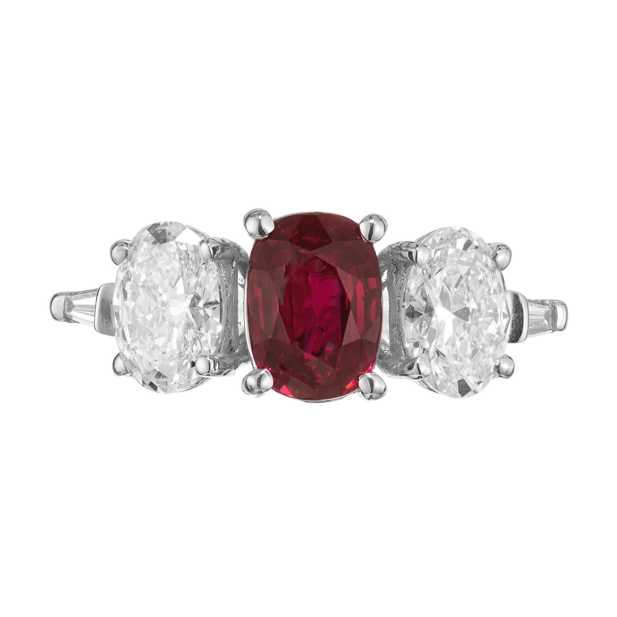 Exquisite ruby and diamond engagement ring. The ring begins with a GIA certified oval center ruby totaling 2.02cts. Mounted in a platinum setting and paired with two perfectly matched dazzling GIA certified oval accent diamonds totaling 1.46cts. 2