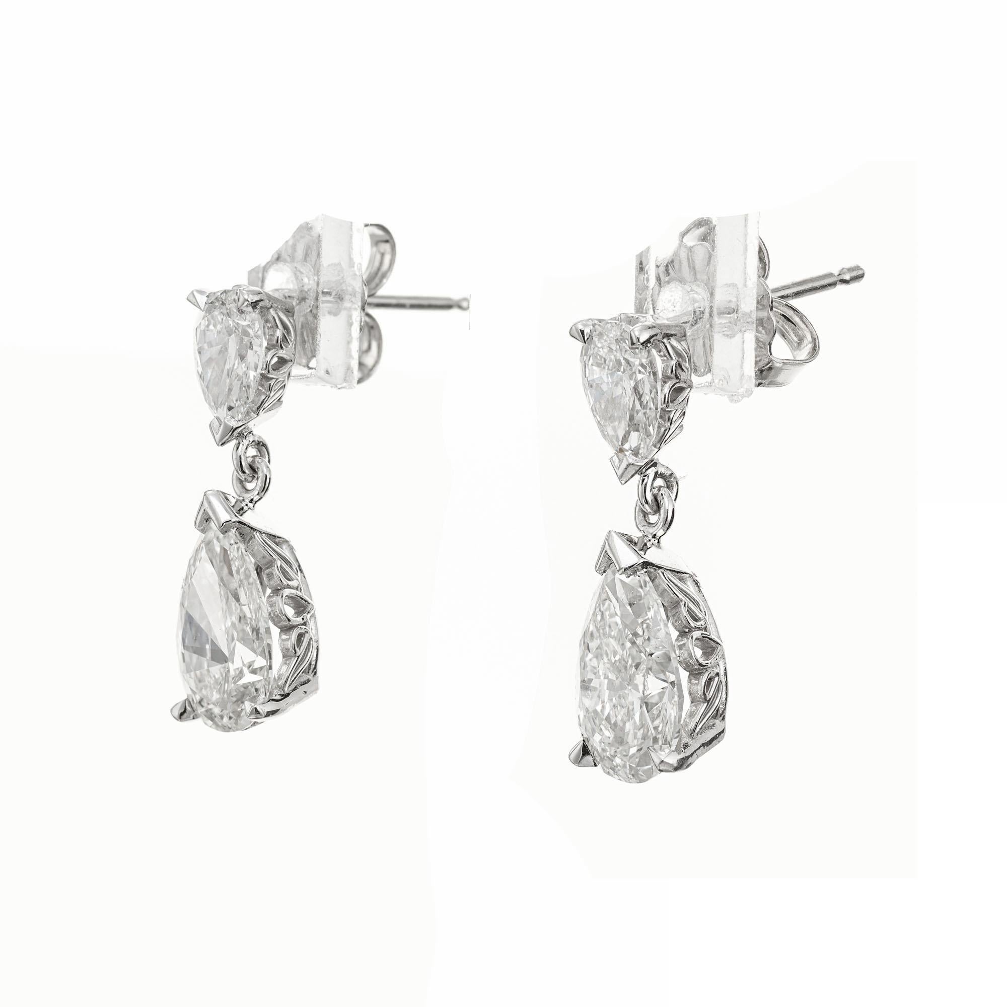 Platinum scroll design pear shape diamond dangle earrings. The bottom two diamonds are GIA certified, with 2 top pear shaped diamonds set in platinum. Designed and crafted in the Peter Suchy workshop 

1 pear shape diamond, J SI2 approx. 1.01cts GIA