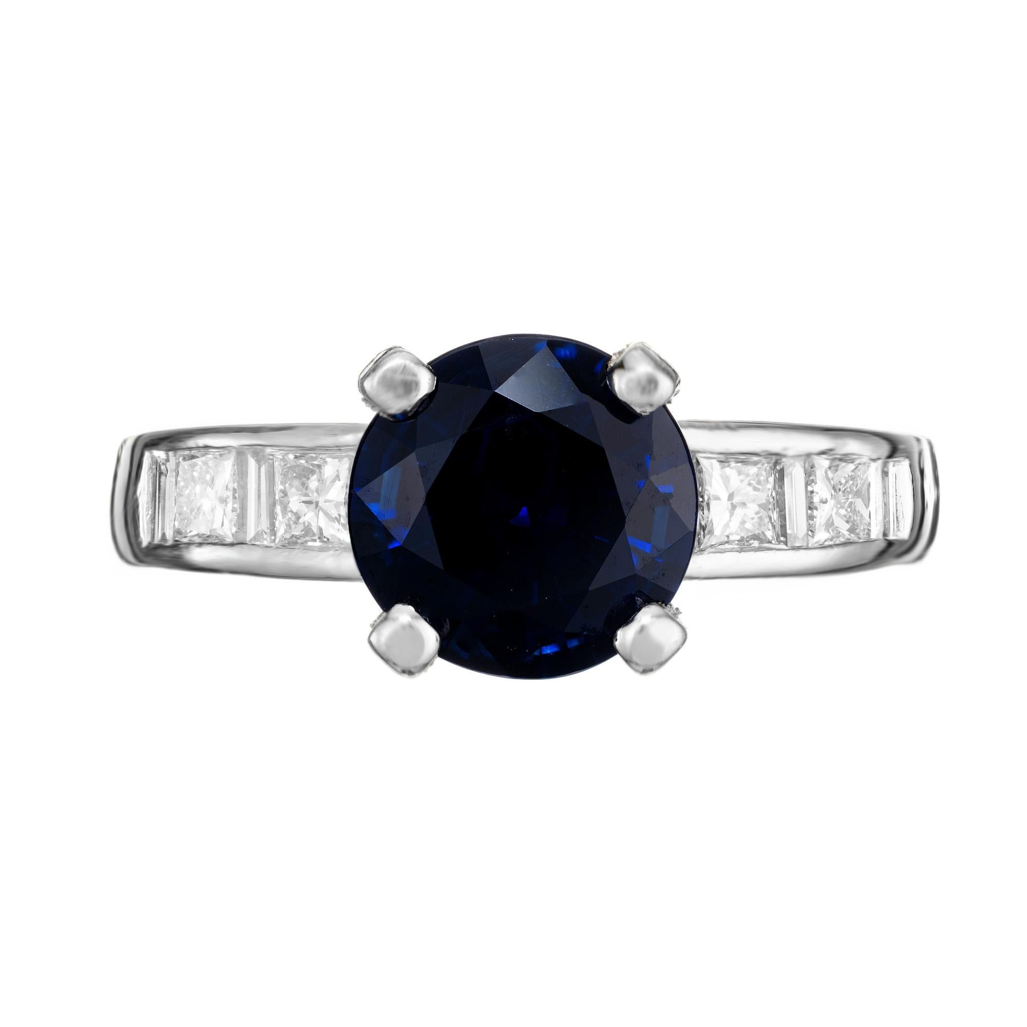 This exquisite ring features a mesmerizing 2.62 carat rich blue, round sapphire center stone, mounted in a platinum setting and accented by 4 princess and 6 straight cut baguette diamonds, creating a radiant contrast that captures the light and