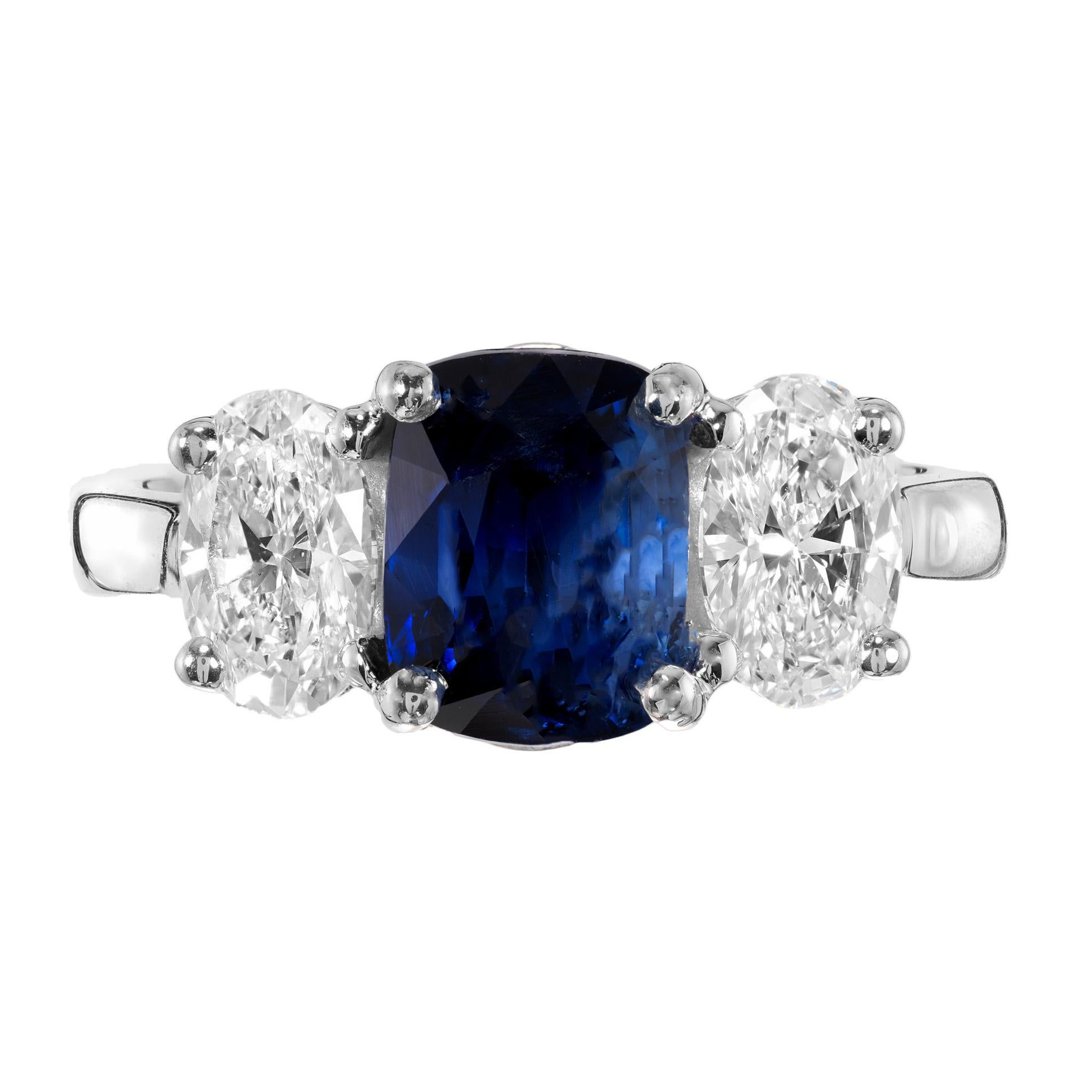 Velvety, rich blue sapphire and diamond engagement ring. Spectacular 2.79ct cushion cut center sapphire, mounted in a platinum three-stone setting. The sapphire is accented by 2 sparkly oval cut diamonds totaling 1.20cts. The sapphire is GIA