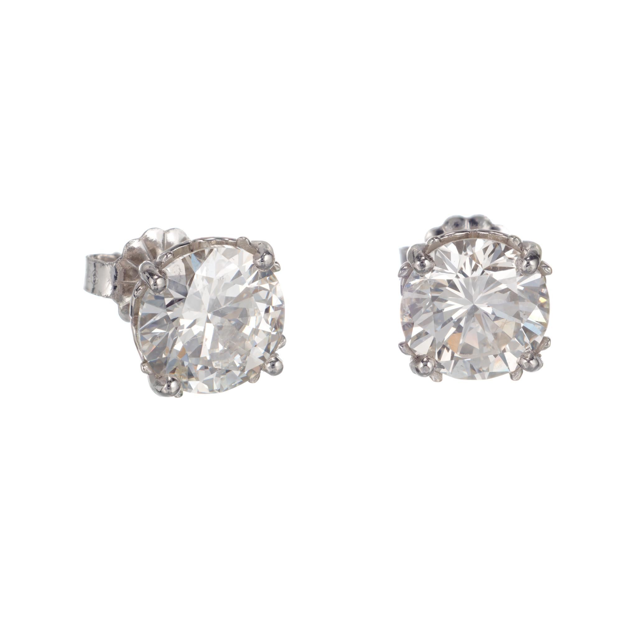 3.00 carat round brilliant cut diamond stud earrings. Set in platinum open work scroll baskets from the Peter Suchy Workshop

1 round brilliant cut K SI2 diamonds, Approximate 1.50cts GIA Certificate # 5171342072
1 round brilliant cut J I diamonds,