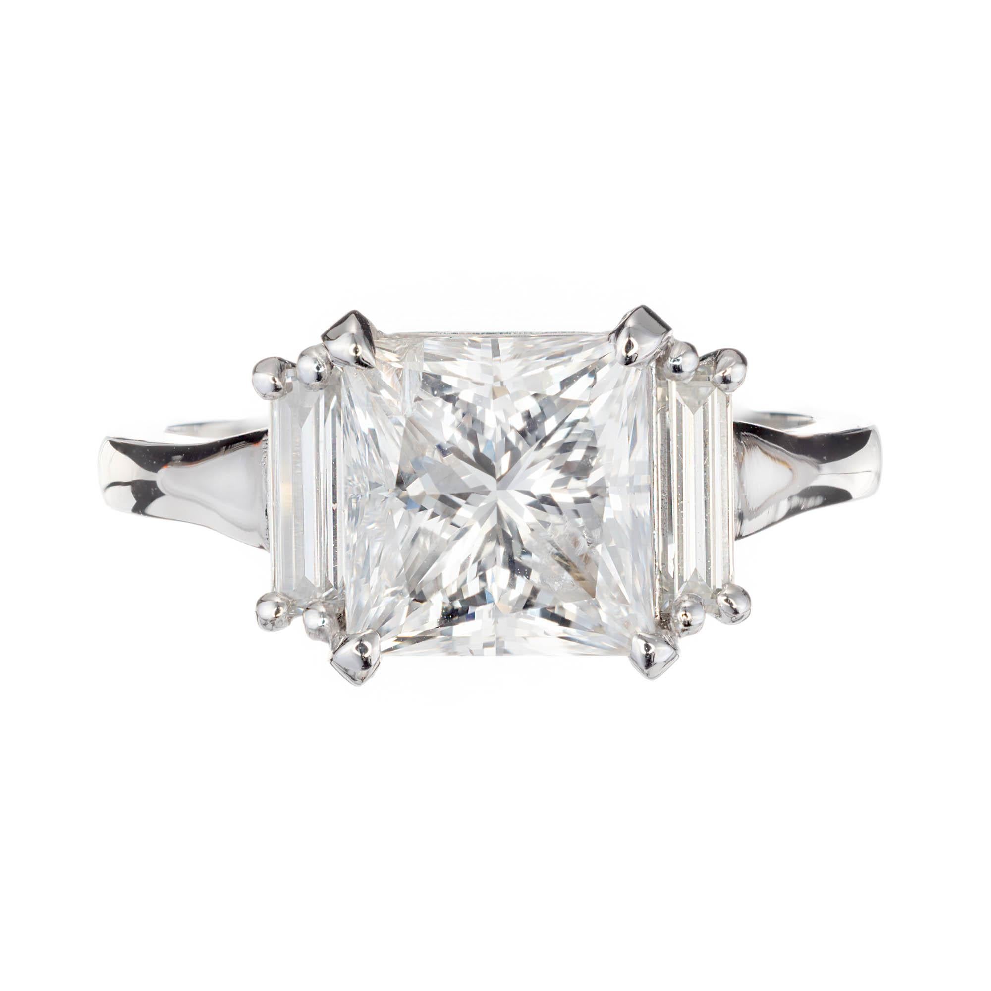 Peter Suchy princess cut three-stone diamond engagement ring. Gia certified square center diamond accented with 2 baguette diamonds in a platinum setting.  

1 square brilliant H I diamond, Approximate 3.05 carats. GIA Certificate # 6197412152
2