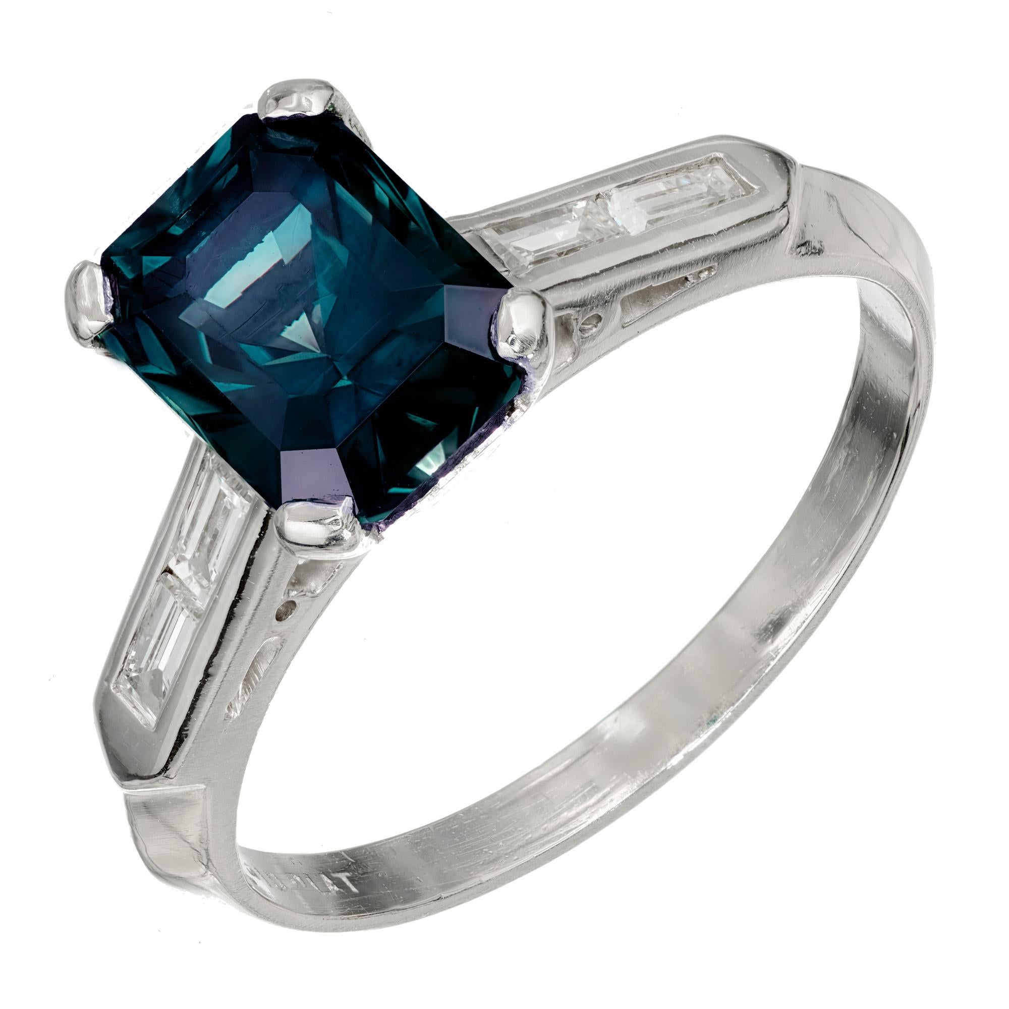 Green Sapphire and diamond engagement ring. Octagonal green sapphire center stone in a platinum setting with four baguette accent diamonds.  The ring is designed to show off the rich natural, untreated greenish blue color of the sapphire. Crafted in