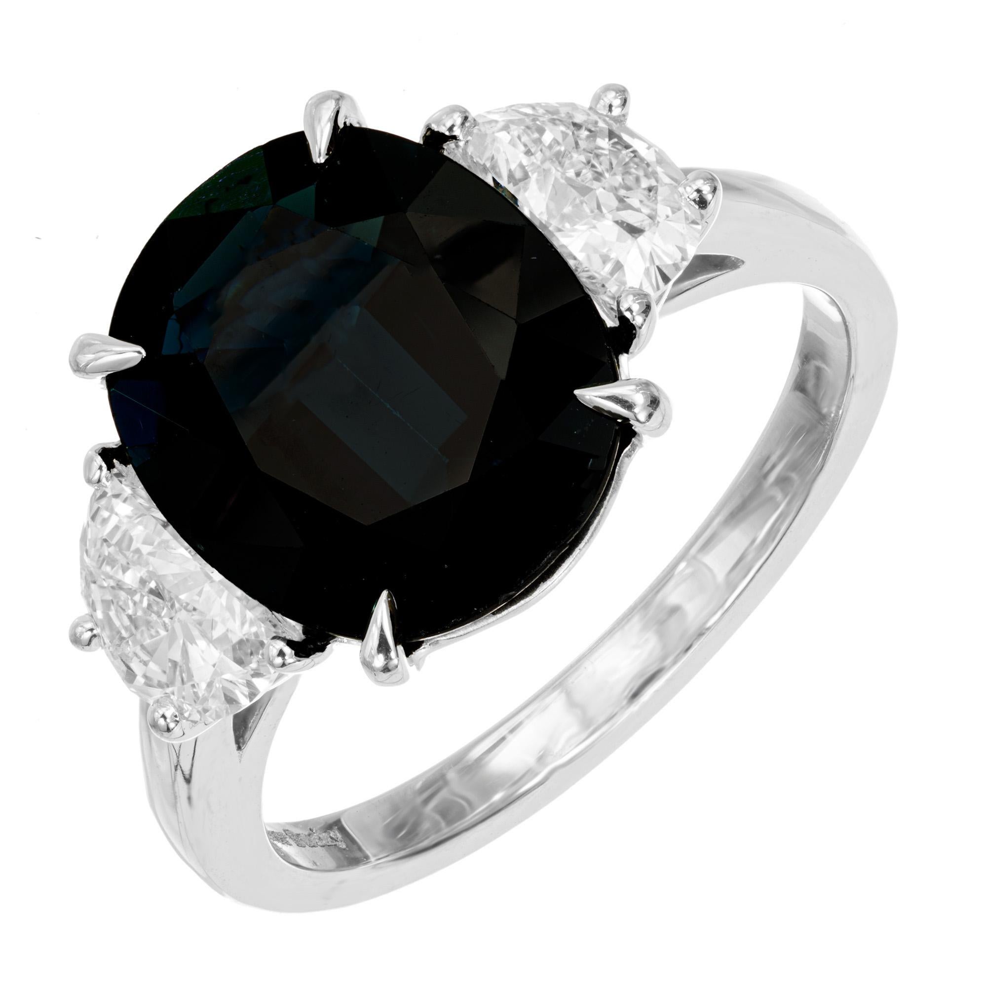 GIA Certified natural untreated deep blue sapphire with a slight green overtone 5.09 carat with the surface area of most  7-8 carat sapphires. Contrasted by two bright white half moon diamonds. Designed and crafted in the Peter Suchy Workshop

1