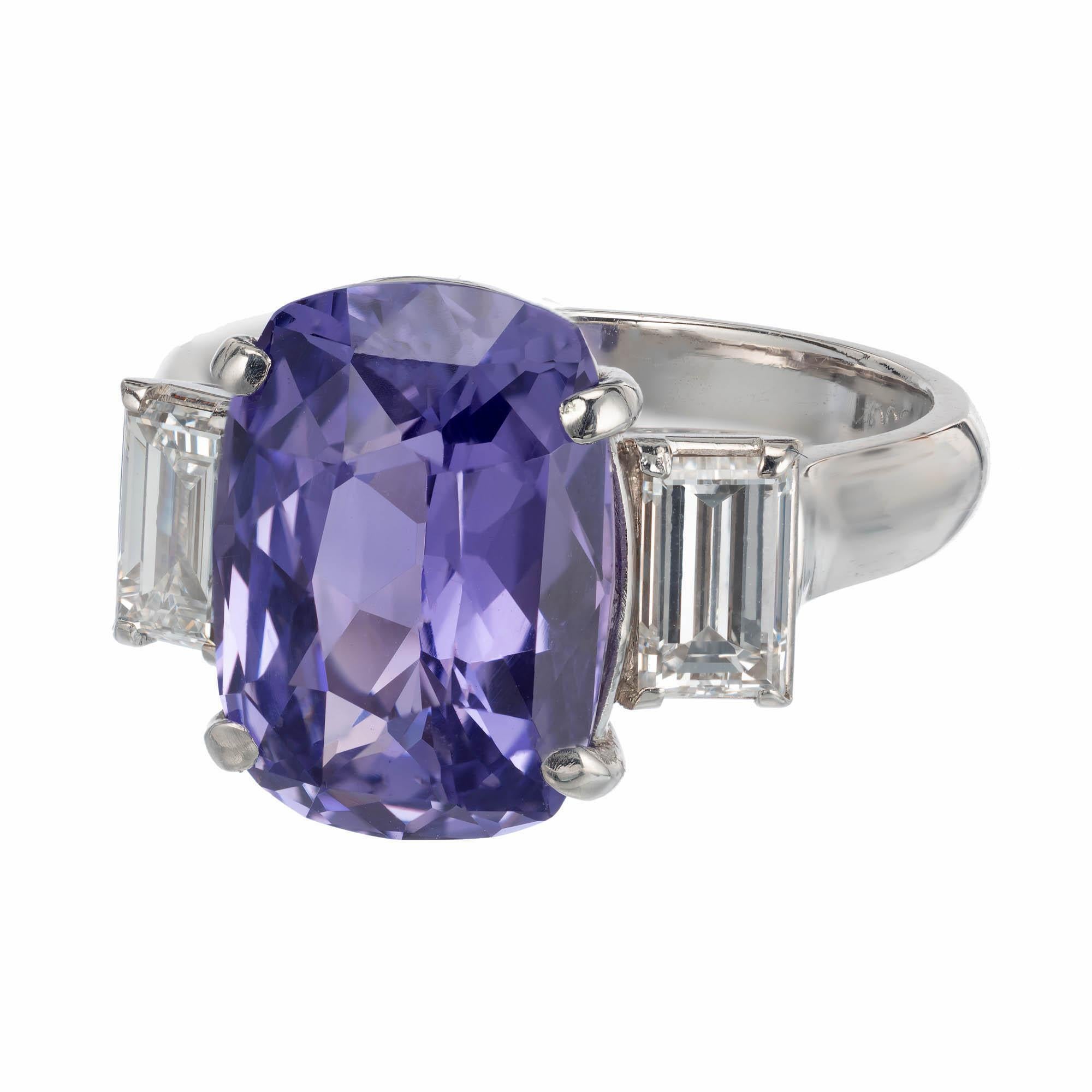 Violet sapphire and diamond three-stone engagement ring. 5.44 carat cushion cut natural sapphire is from a 1900s estate, accented with 2 emerald cut diamonds in a platinum setting, crafted in the Peter Suchy Workshop.

1 cushion brilliant cut violet