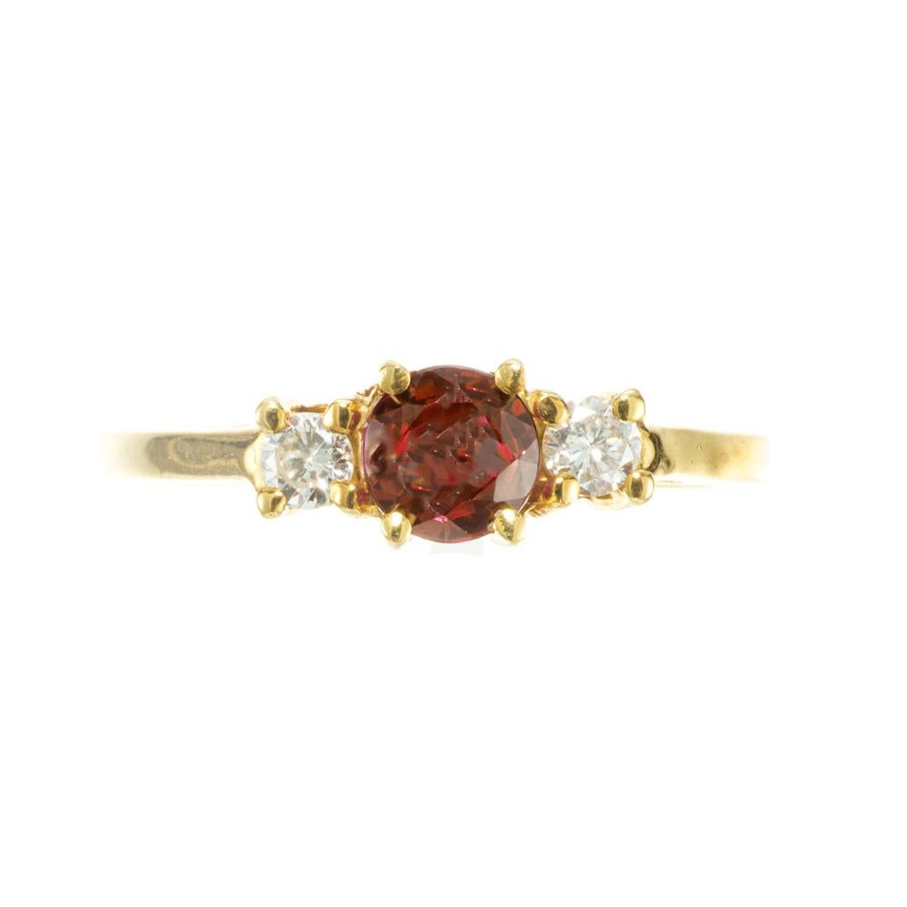 Ruby and diamond engagement ring. GIA certified natural no heat round center ruby mounted in a simple 18k yellow gold three-stone engagement ring setting accented with two round cut diamonds. The GIA graded this ruby as natural, no heat and the