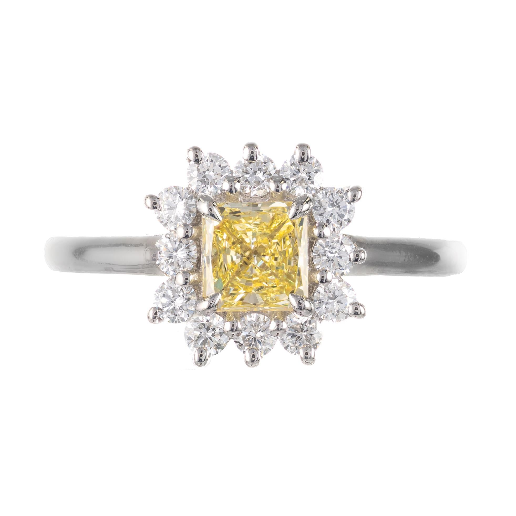 0.55 carat fancy yellow radiant cut diamond and white diamond engagement ring. Rectangular yellow diamond center stone with a halo of  12 round diamonds set in a platinum setting from the Peter Suchy Jewelers Workshop.  

1 rectangular natural fancy