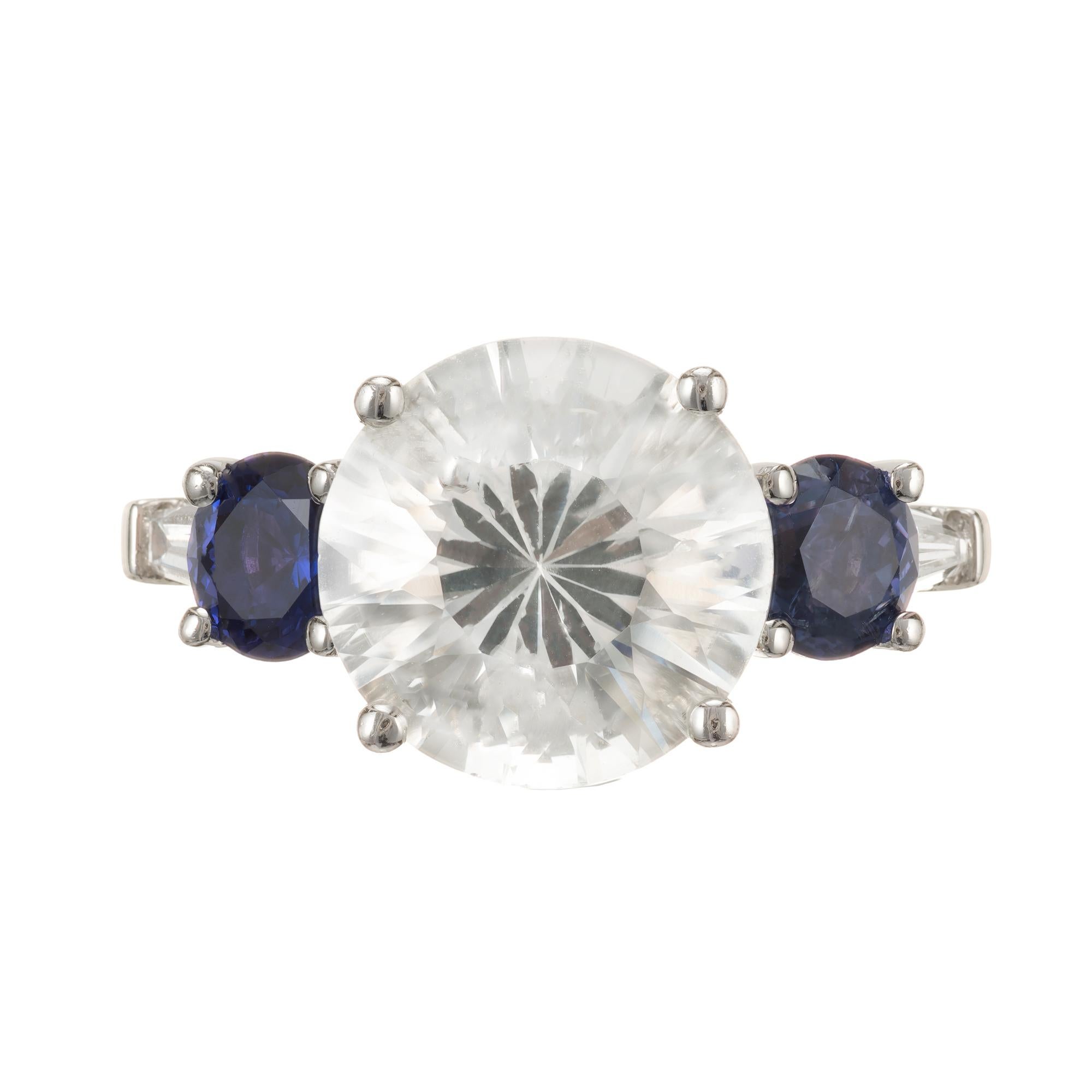Round sapphire and diamond engagement ring. White Natural corundum natural Sapphire, no heat or enhancements Sapphire. The cut is old European brilliant with a raised crown and small table. On the either side of the center are two AGL certified old
