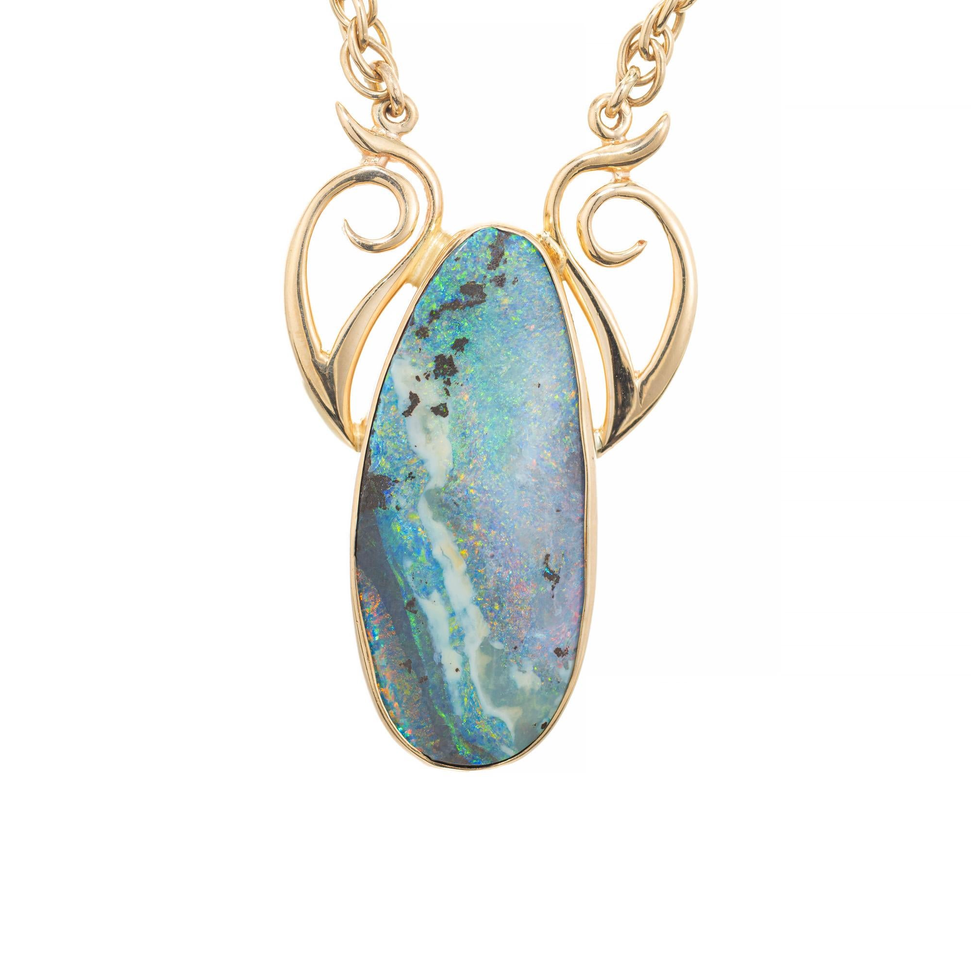 Opal pendant necklace. Natural oval free form Australian boulder opal on rock matrix (not a doublet or triplet) in a simple 14k yellow gold pendant with a 19 inch double link rope chain. Designed and crafted in the Peter Suchy Workshop.
Boulder opal