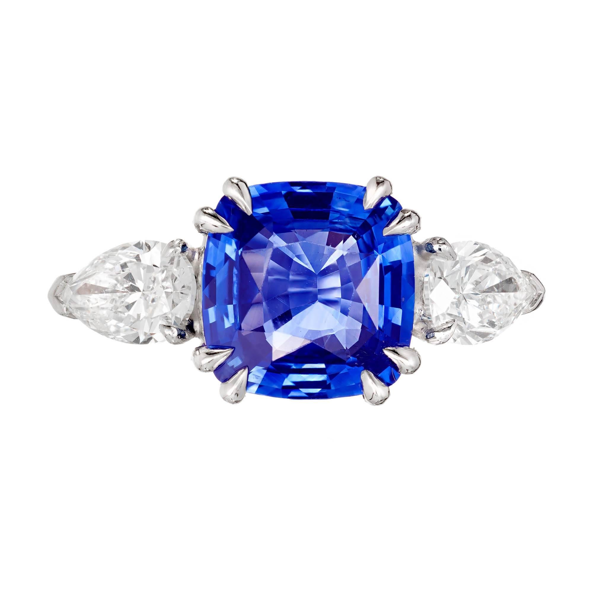 Peter Suchy Sapphire Diamond Three Stone Platinum Engagement Ring. Made in Peter Suchy Workshop. Center stone AGL certified. 2 pear shaped GIA certified side diamonds.

1 cushion cut bright blue Sapphire, approx. total weight 4.50cts, simple heat,