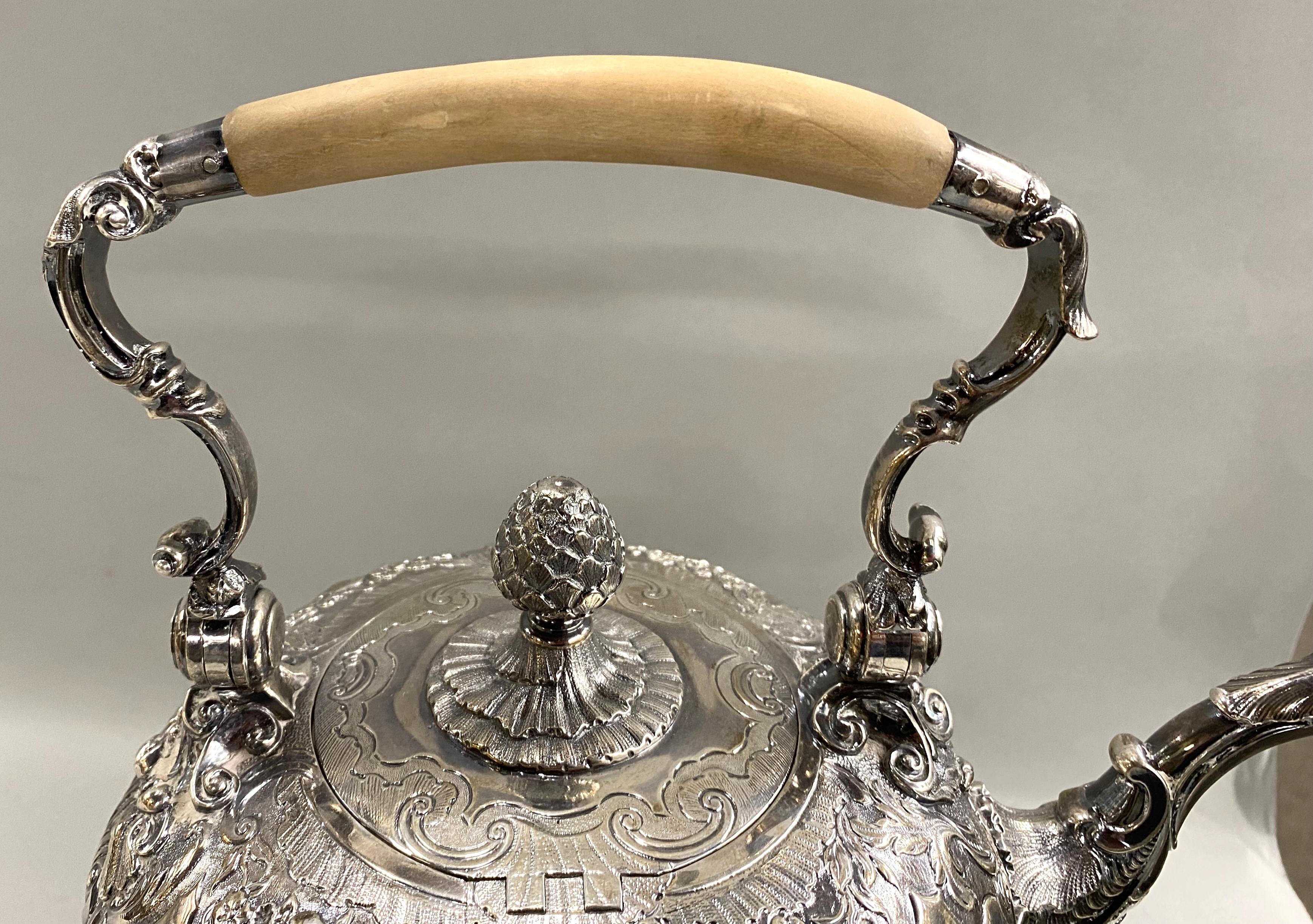 Eccezionale bollitore in argento sterling a forma globulare su supporto, marchiato dall'argentiere londinese A. Taylor nel 1741, con bordo e supporto a fasce floreali, al centro con cartiglio, con finale a pigna e manico basculante. Meravigliosi i