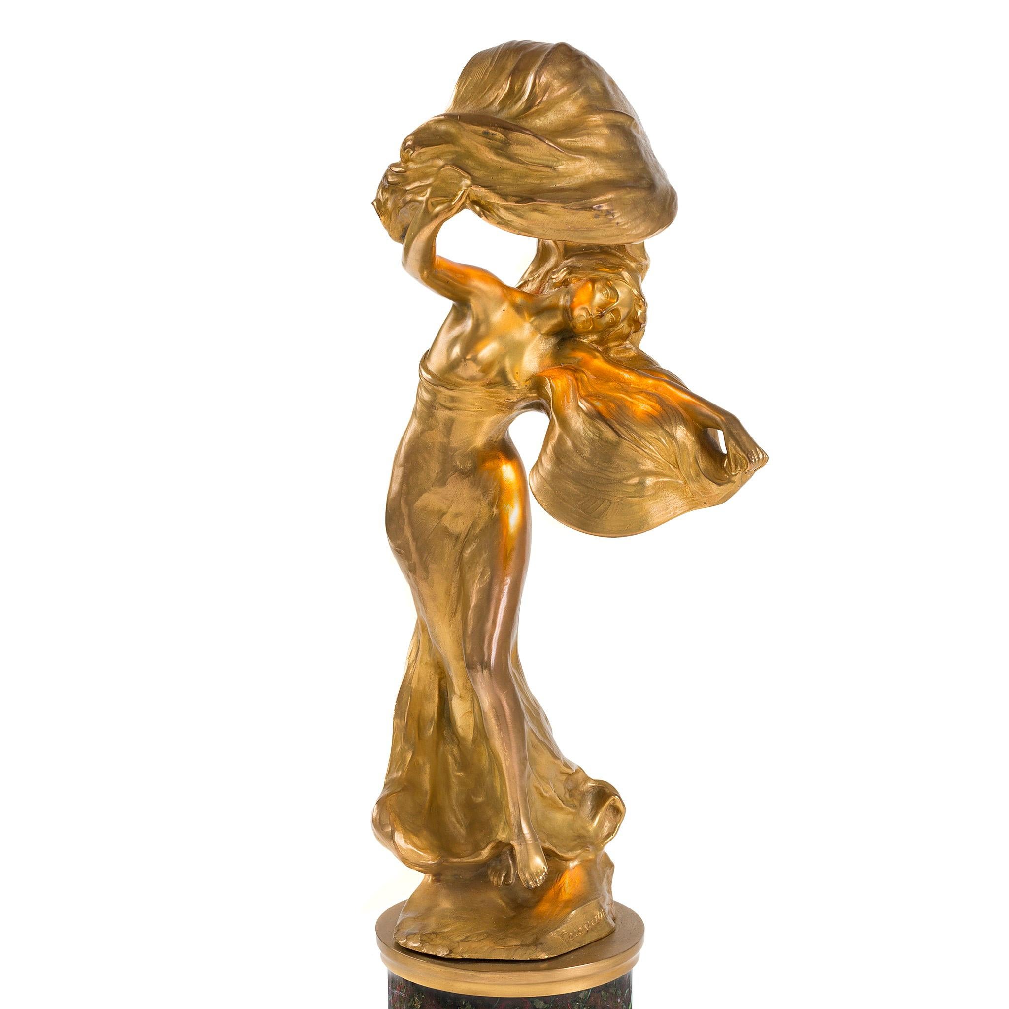 This brilliant sculpture is Peter Tereszczuk's depiction of the American muse to many, the Art Nouveau era dancer, Loïe Fuller. In this gilt bronze statue, Tereszczuk captures Fuller mid-movement, a swirling veil of scarves fluttering ethereally