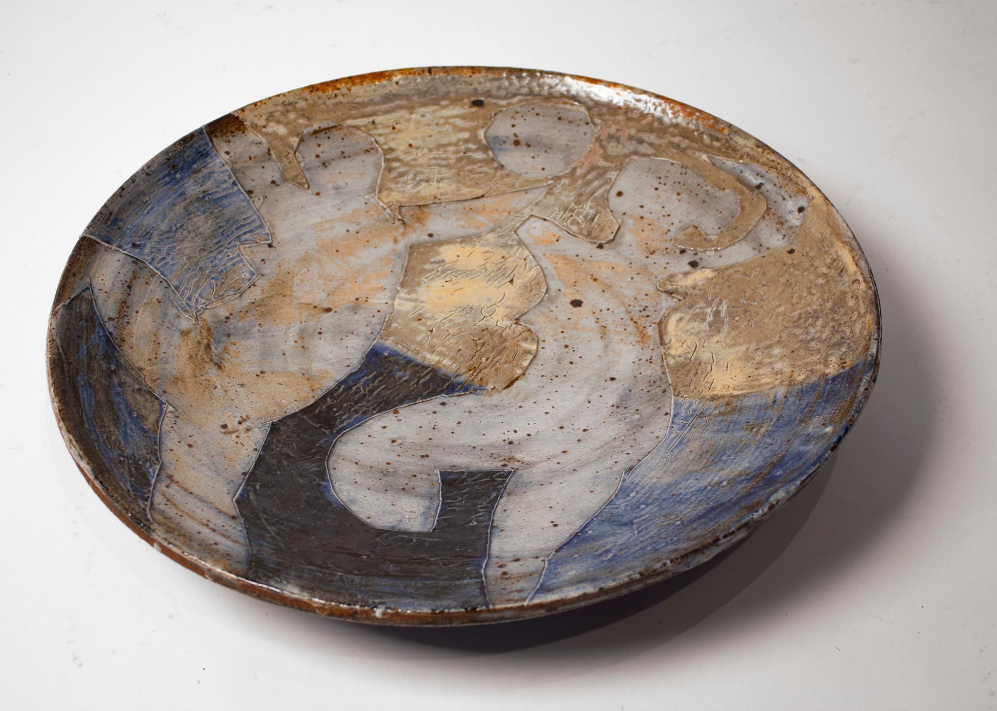 An early glazed stoneware platter from the breakthrough years of world-renowned sculptor Peter Voulkos. Originally purchased in the mid-1950s and acquired from the original owner. 

This charger depicts two female nude forms dancing under the
