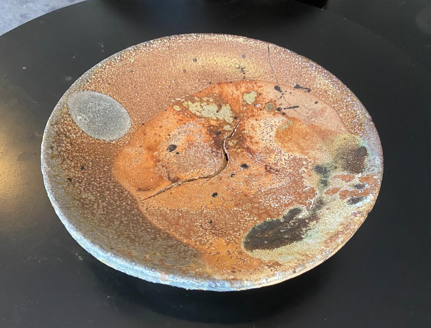 Un fantastico piatto/caricatore da parete a legna Anagama, dal design accattivante, realizzato dal maestro ceramista/artista americano Peter Voulkos, universalmente noto per le sue ceramiche e sculture espressioniste astratte.  Il pezzo, grande e