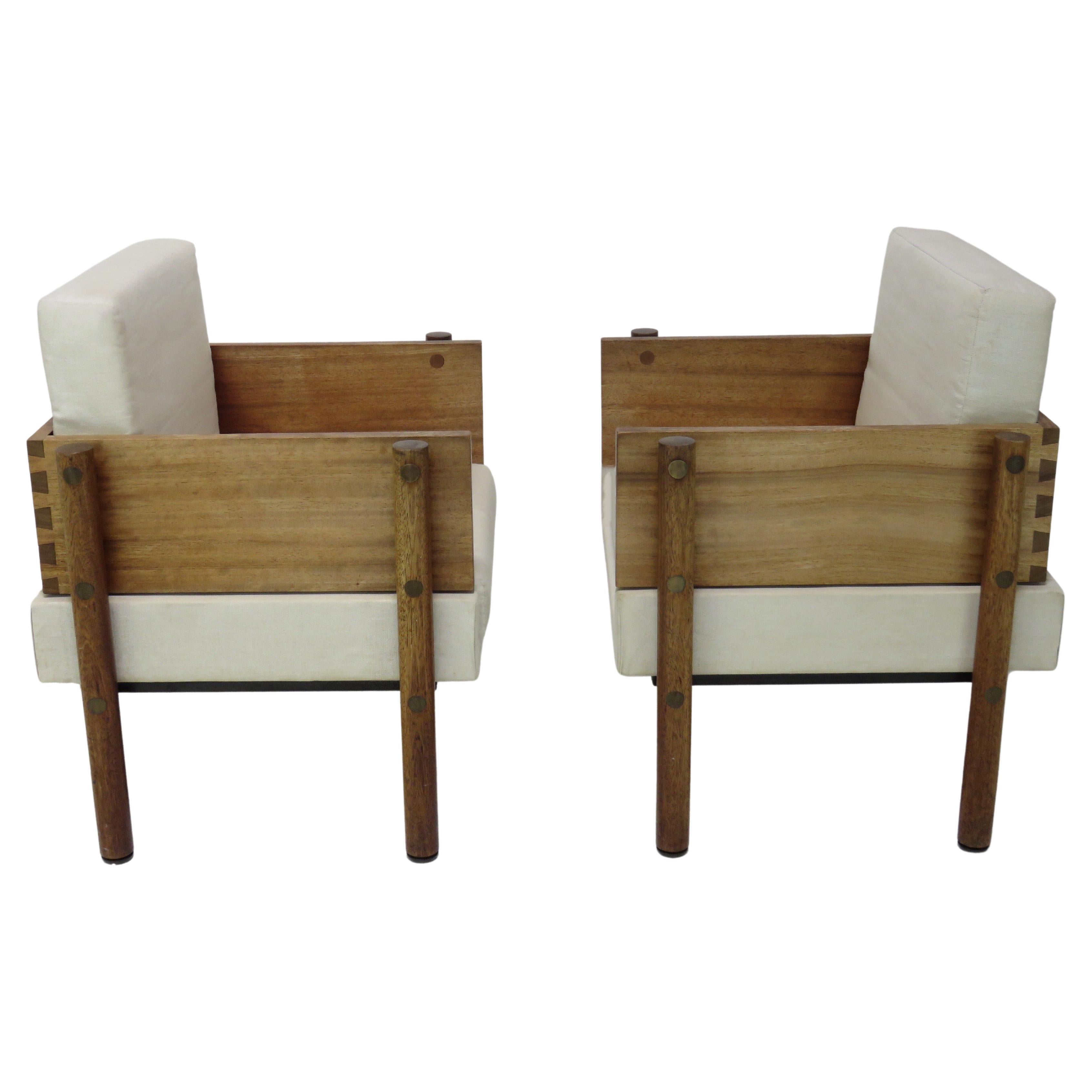 Architect / Designer pair of lounge chairs are of solid Mahogany, with brass accents. The cushions soften the cubic form seats that sit atop solid round hard wood legs. 