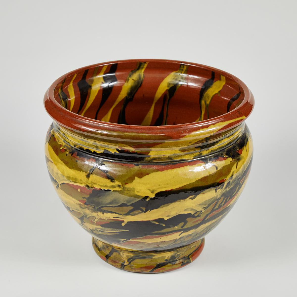 Peters and Reed glazed pottery vase or pot. Richly dimensional multi-colored glazing in shades of mustard, ink, moss, and terracotta give the piece a sense of movement. Because the glaze has been applied in an energetic and abstract pattern, it
