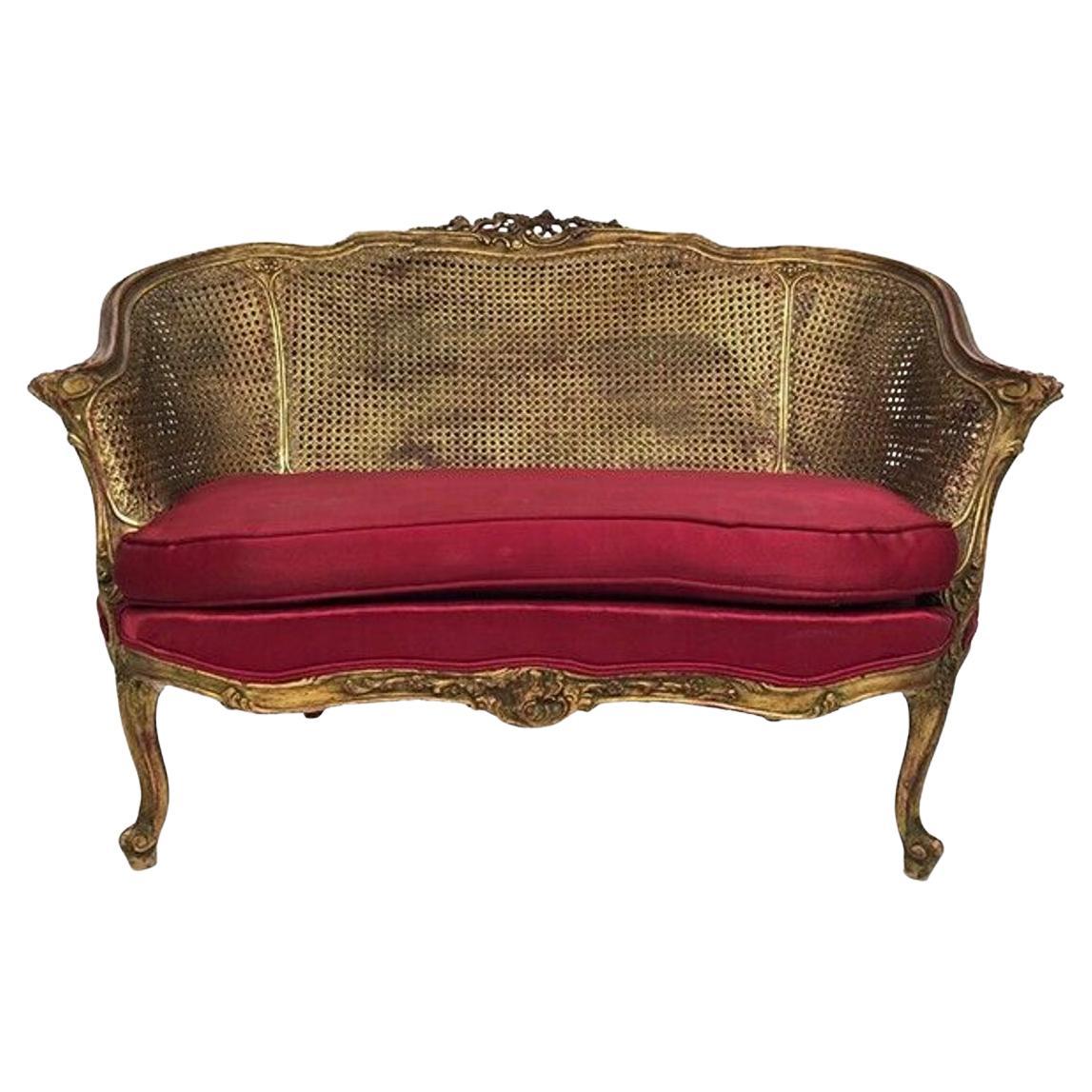 Petit canapé corbeille de style Louis XV, bois doré et double cannage