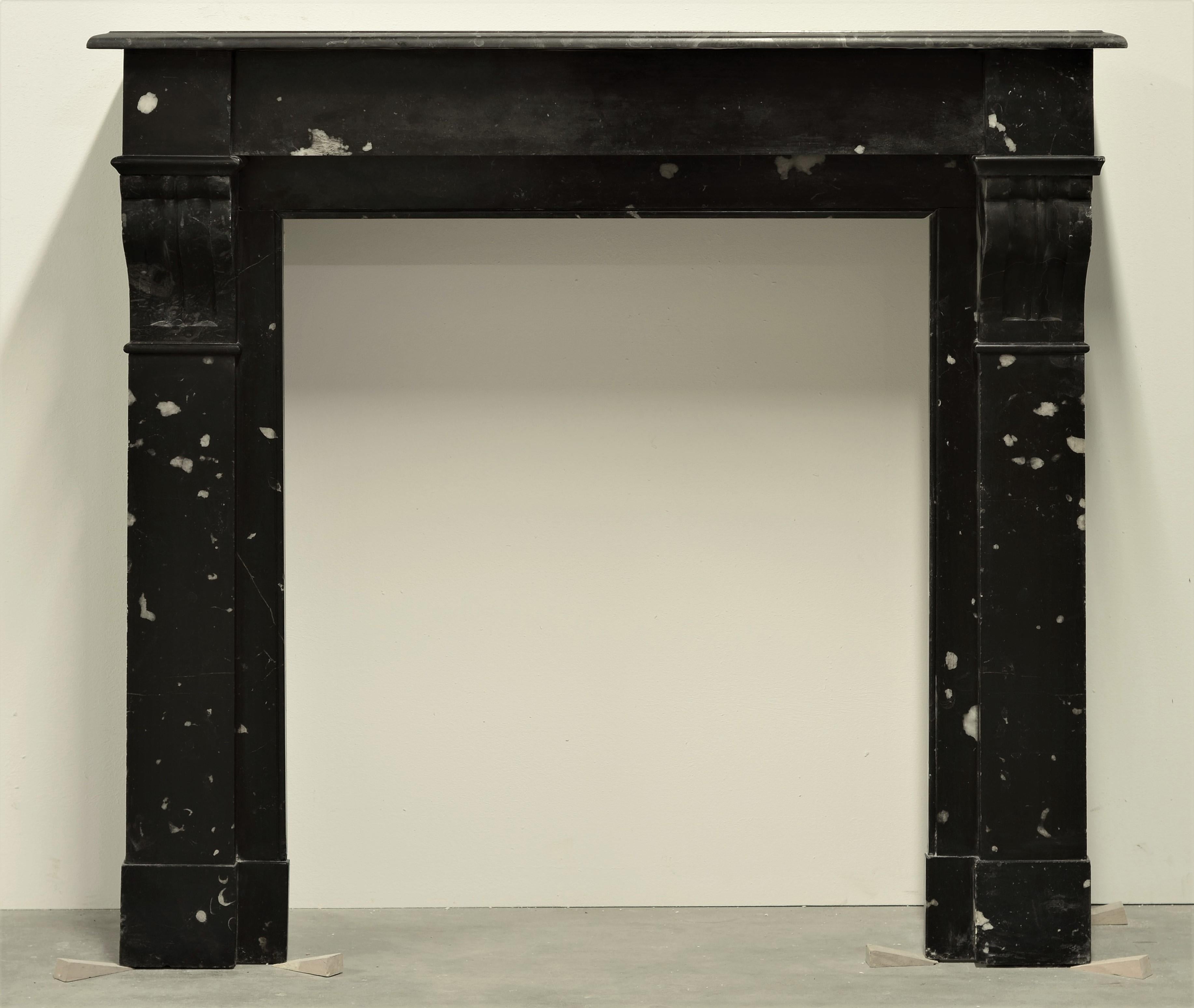 Lovely little French fireplace mantel in the style of Louis Philippe.
This black and white spotted marble gem was installed on a movie set, the wooden mounting blocks are still in place.

Great dimensions and suitable for any kind of