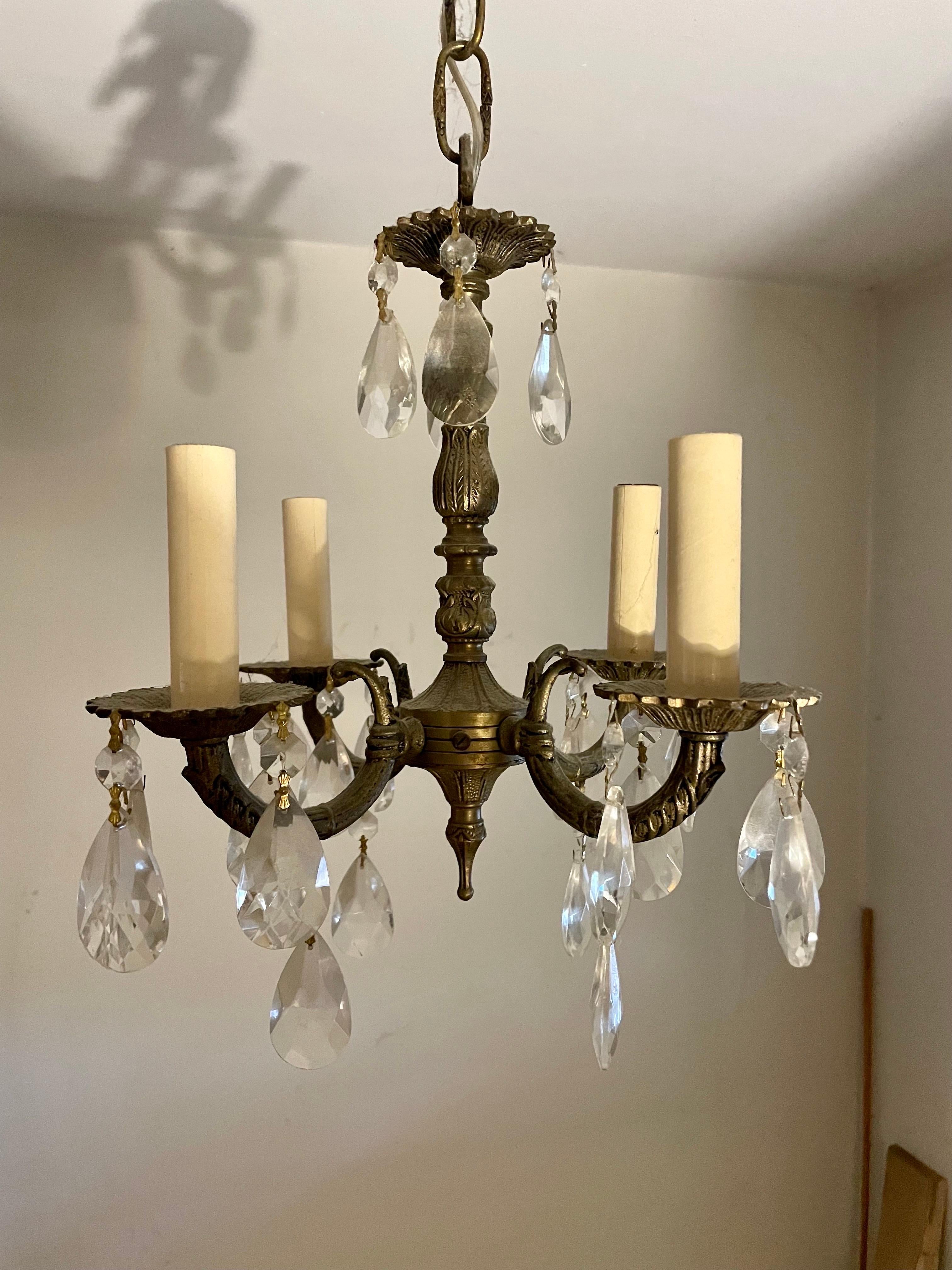 Brass and Crystal French Style Chandelier featuring shimmering crystals mounted on a detailed brass frame. Rewired with clear wire. Four arms with candelabra sockets. Chandelier measures 12