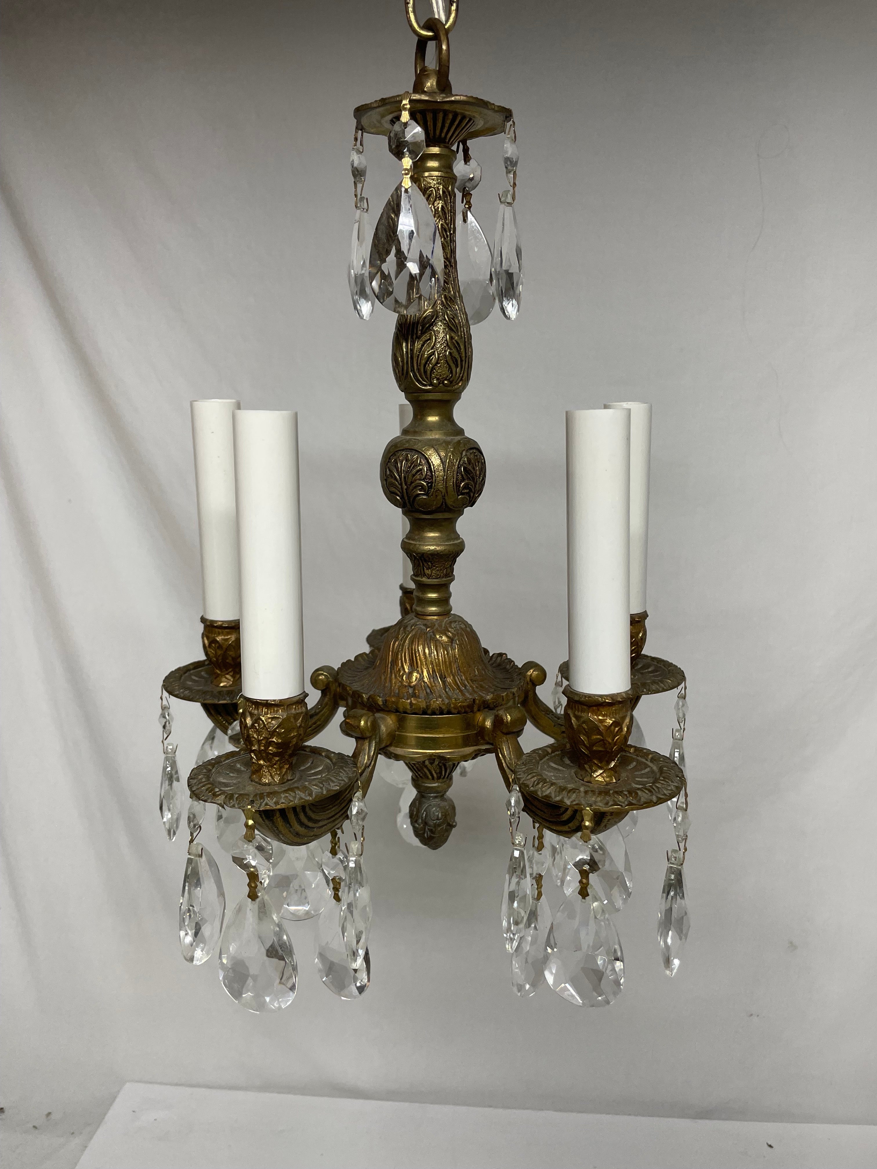 Brass and Crystal French Style Chandelier featuring shimmering crystals mounted on a detailed brass frame. Rewired with clear wire. Five arms with candelabra sockets. Chandelier measures 10