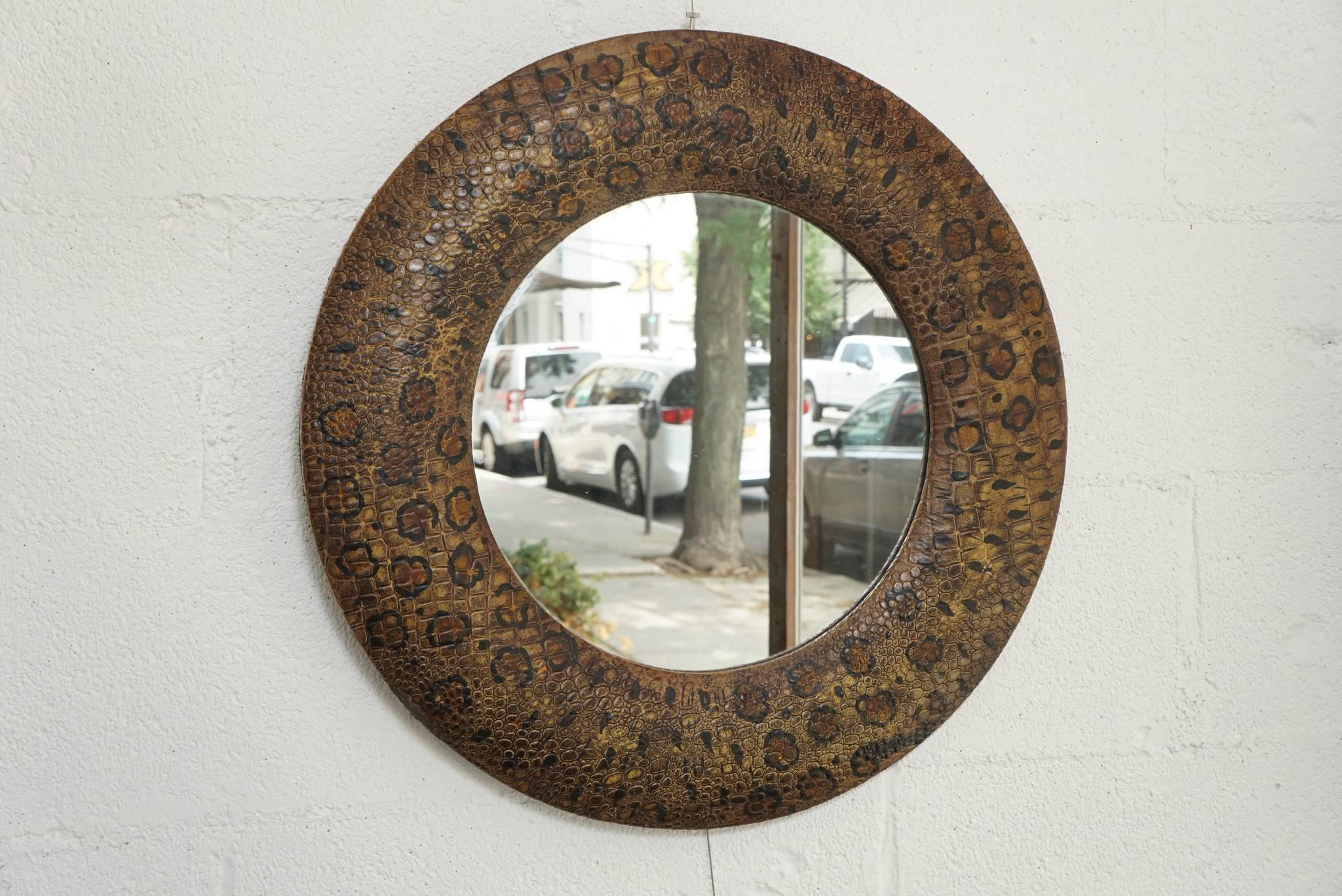 Here is a petit round mirror covered in an embossed leather with a snakeskin motif and hand-painted leopard spots. The frame border is 4.5 inches and the full mirror is 22 inches diameter.