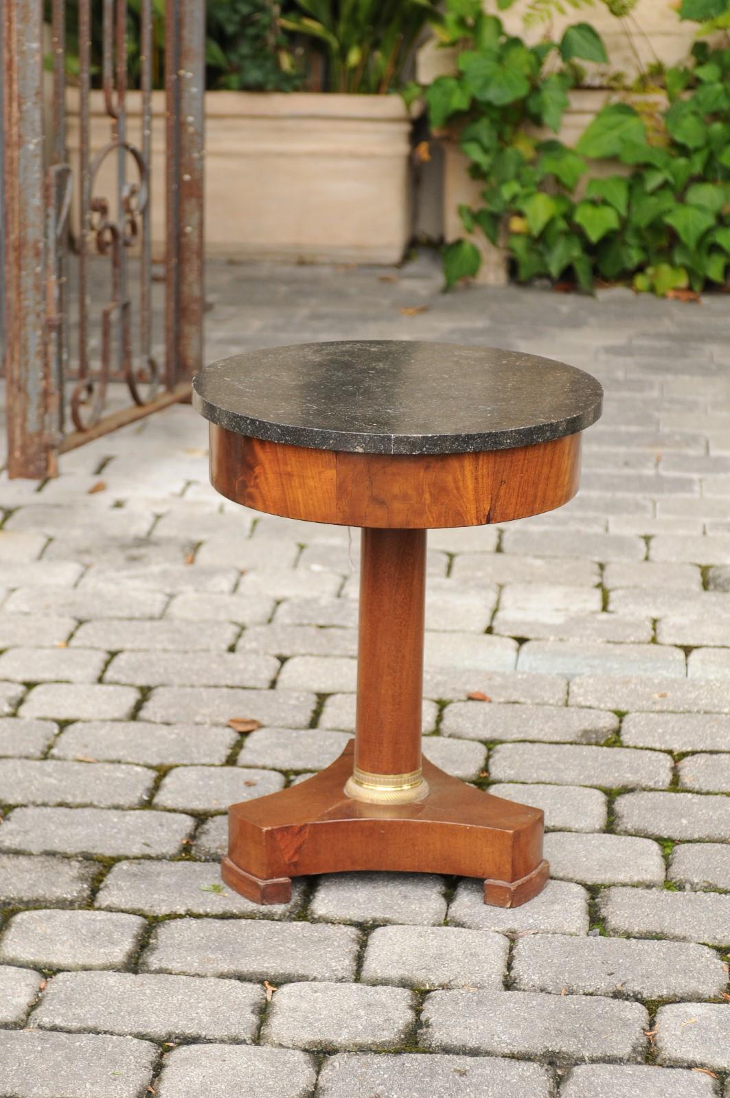 A petite French walnut Empire style guéridon side table from the second half of the 19th century, with grey marble top and pedestal base. Born during the later years of the reign of France's last Emperor Napoleon III, this exquisite small French