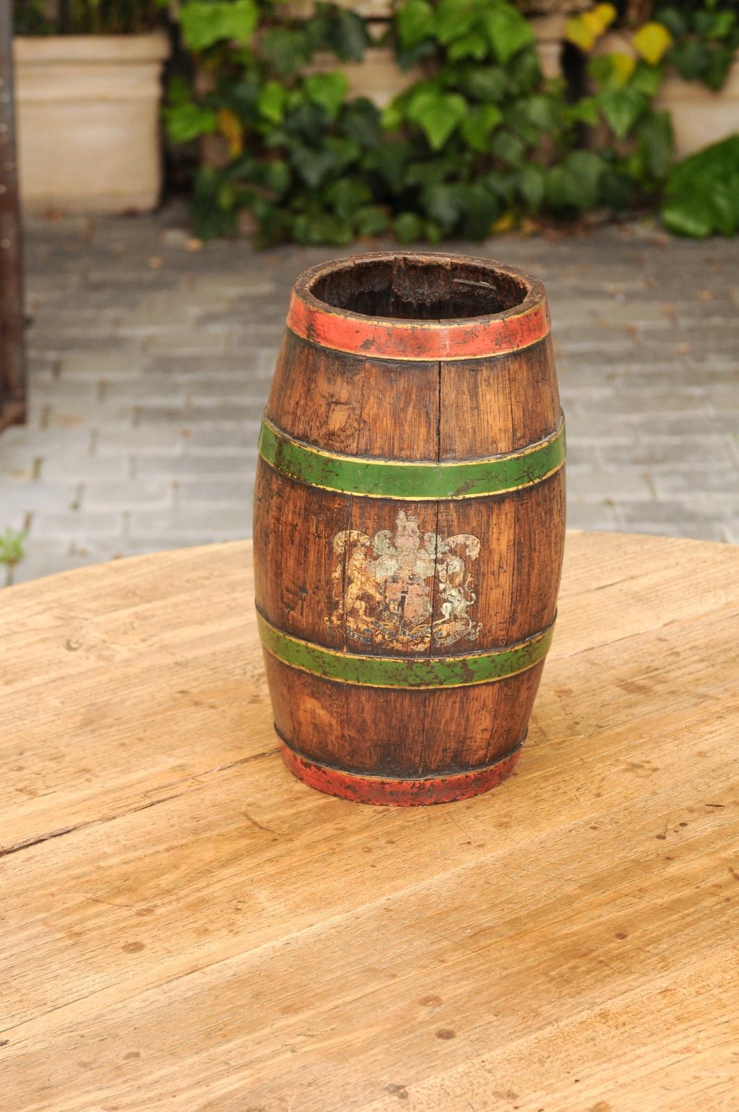 An English Edwardian period small wooden barrel from the early 20th century, with green painted accents and United Kingdom coat or arms. Born in England during the early years of the 20th century, this charming rustic wooden barrel features a