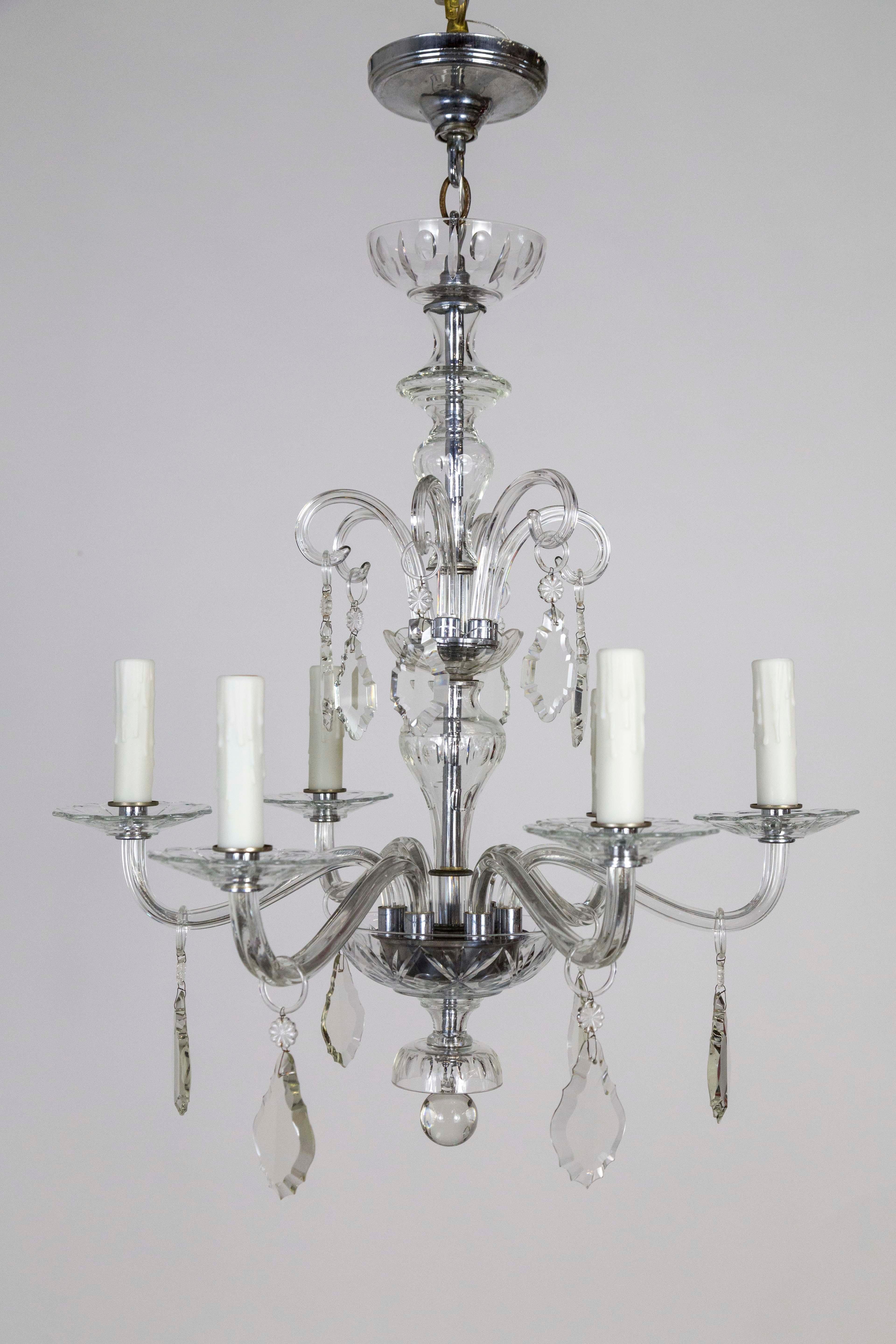 An elegant, antique chandelier; streamlined design with pendeloques crystals hanging from rings off of the 6 glass arms; decorative, molded accents on bowl and bobeches. Measures: 22