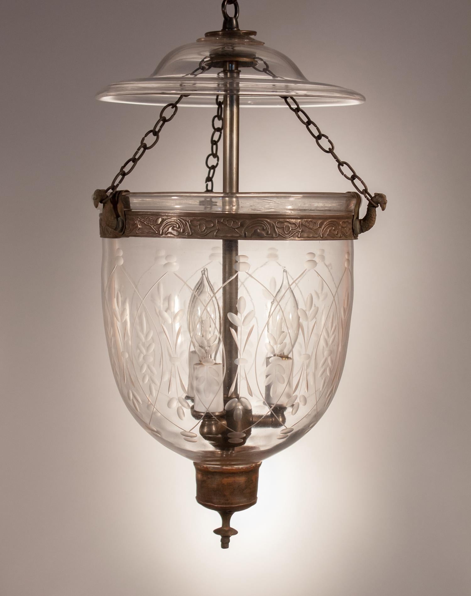 A Classic, smaller-sized English bell jar lantern, circa 1860, with lovely form and its original smoke bell and unadorned brass candleholder base. The bell jar's embossed brass band and chains have been replaced for safety. This petite hall lantern