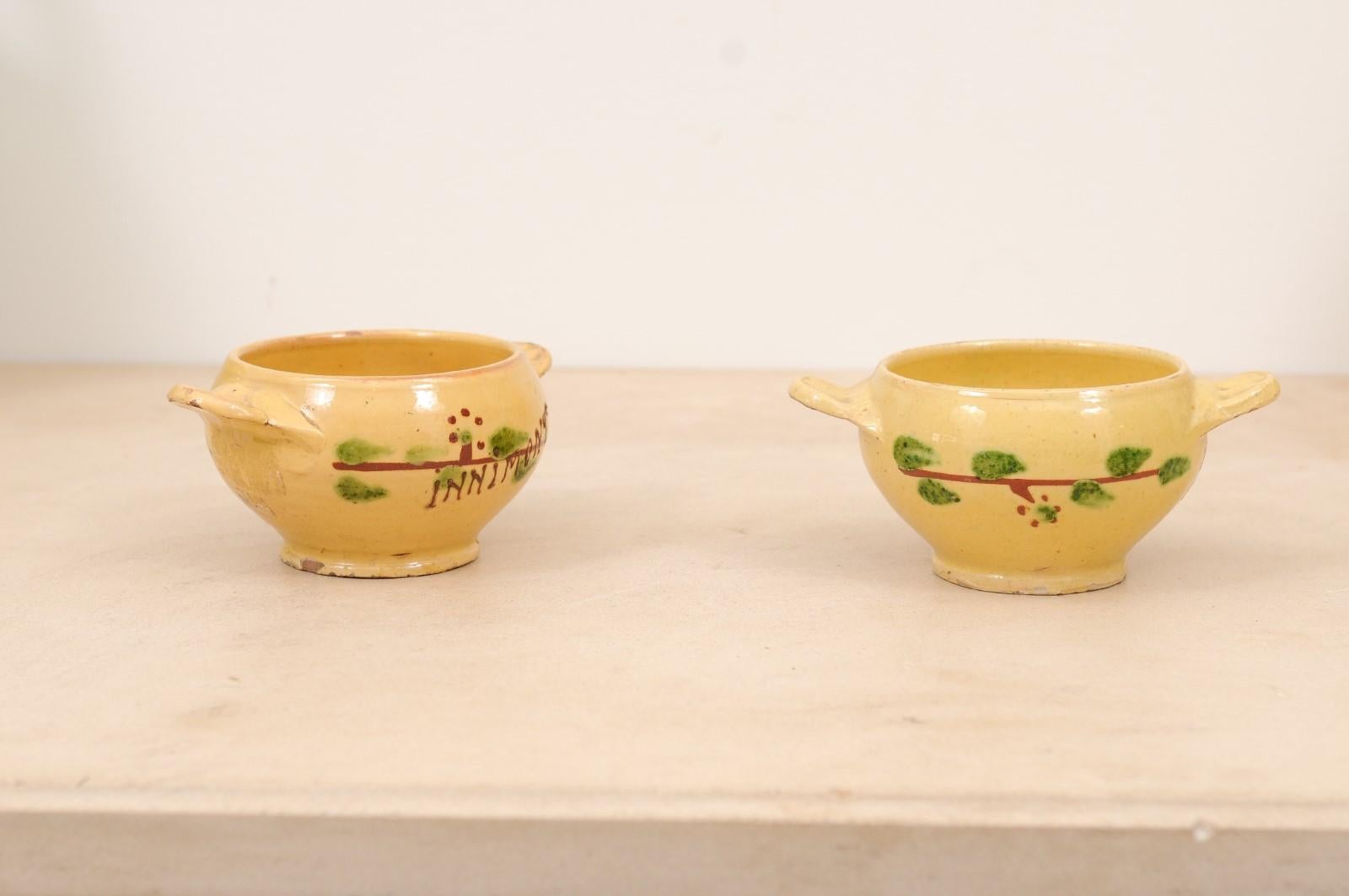 Deux petits bols à boire en poterie à glaçure jaune de la ville d'Innimont, datant du 19e siècle, avec des motifs de feuillage stylisé. Prix et vente séparés : 295 $ chacun. Créés dans l'Est de la France au XIXe siècle et destinés à boire du thé, du
