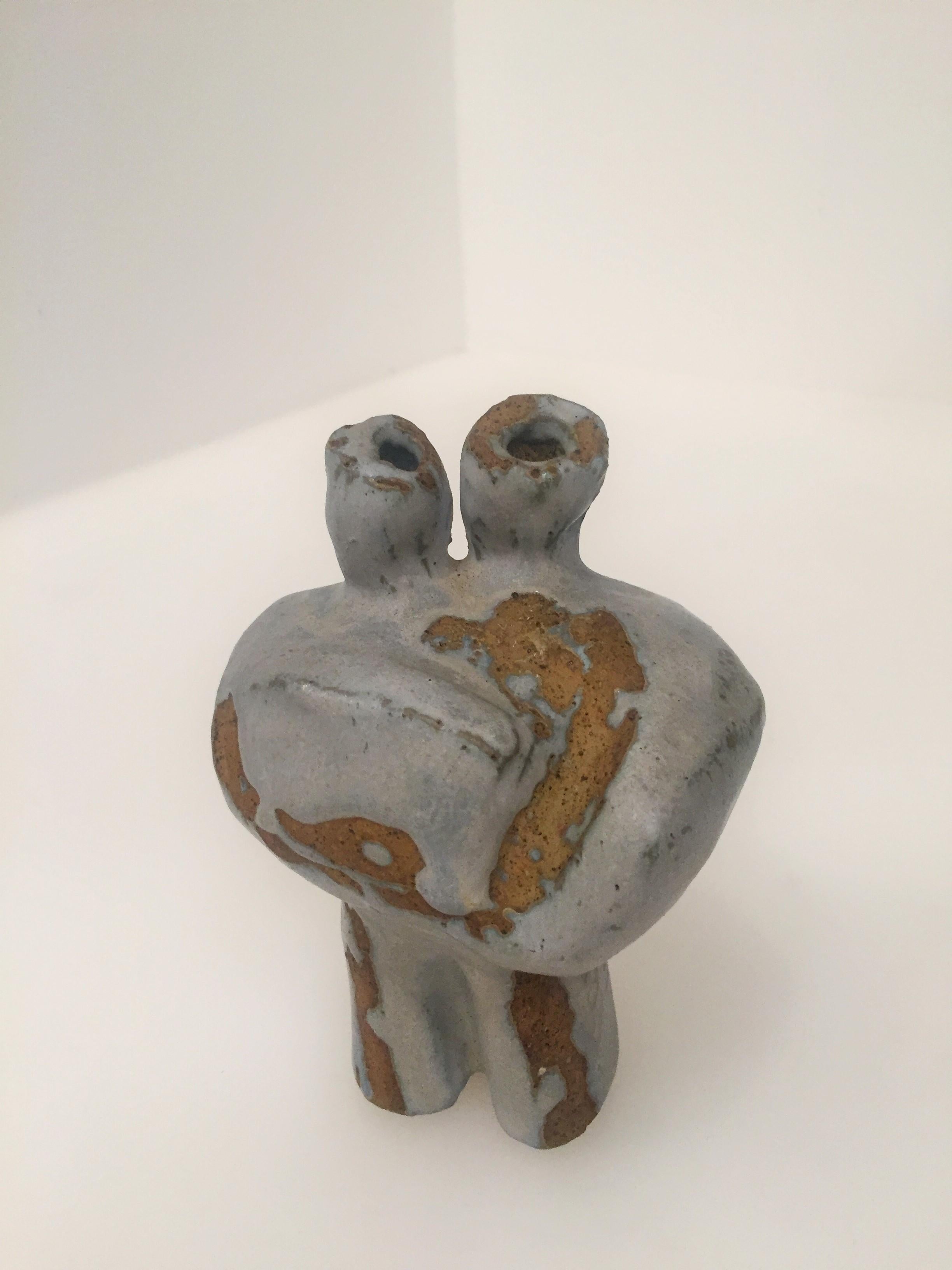 Petite clay abstract sculpture. Made of brown clay that is accented with taupe. This piece may be used as a vase or as a sculpture.


 