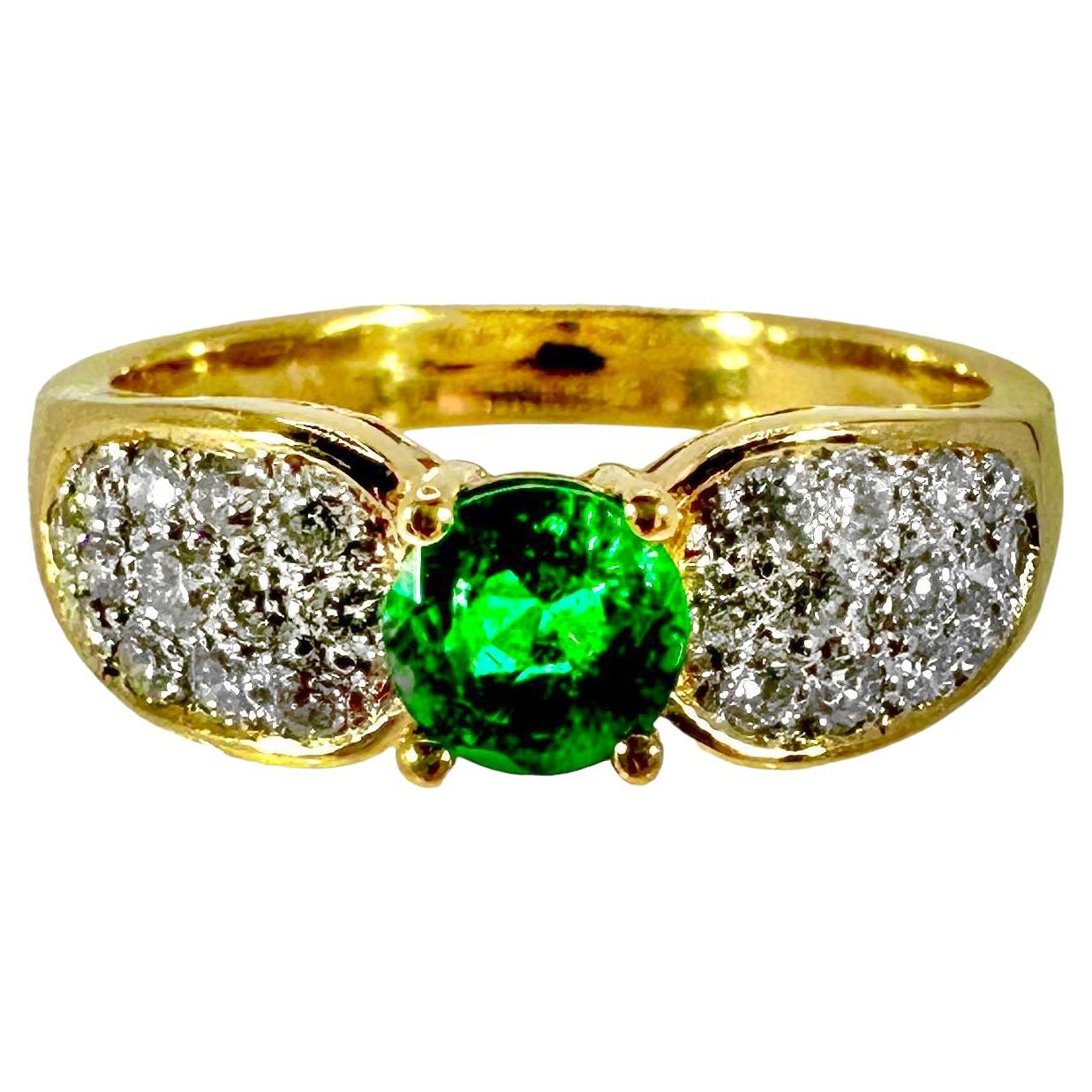 This lovely, traditional ladies fashion ring is set with one vibrant natural emerald having an exact weight of .53ct. This center stone is flanked by a total of 26 brilliant cut diamonds which have a total exact weight of .39ct and an overall