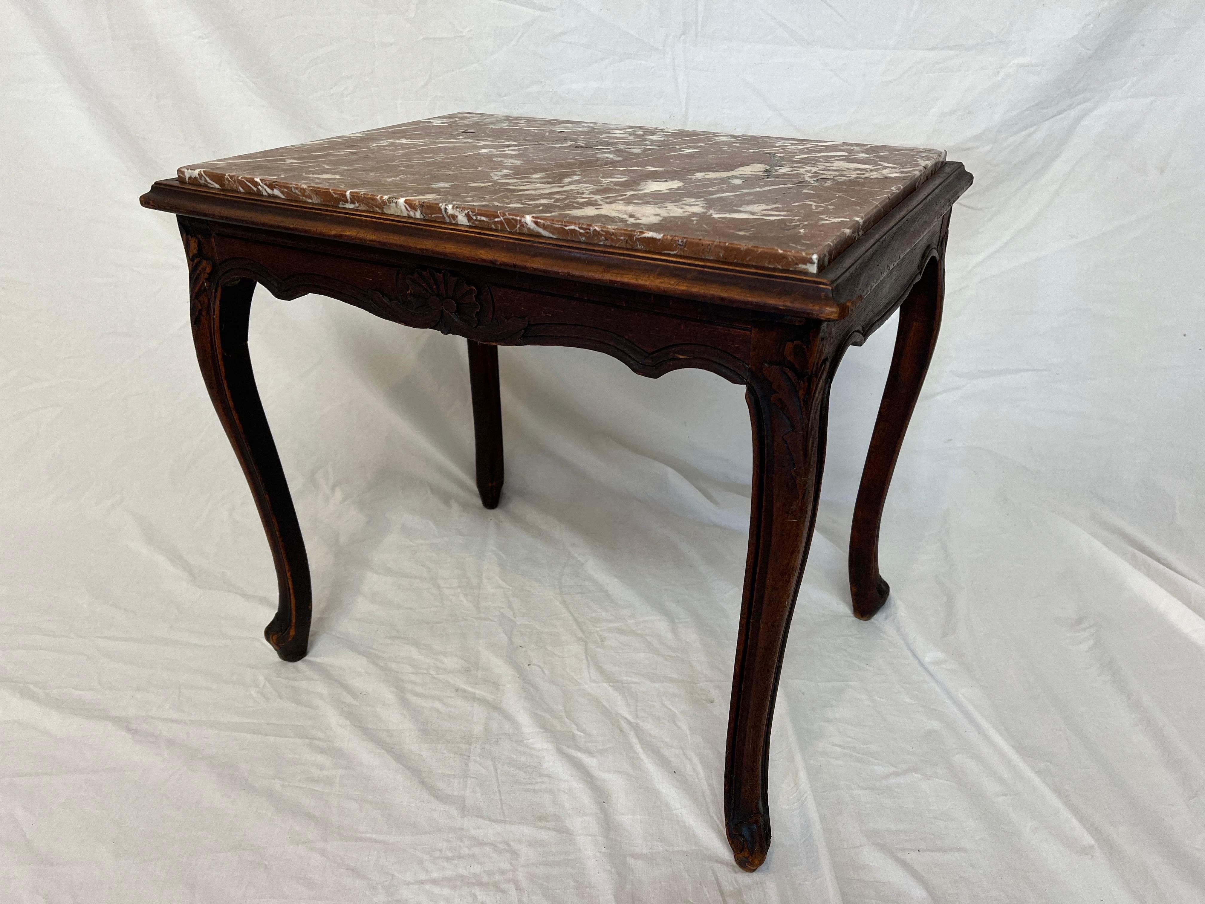 A timeless and beautiful Belgian Louis XV style rouge topped marble side table. The table features lovely carved details on all four sides. With stylized shell and foliate motifs on the wave like aprons and corners, gently flowing cabriole legs and