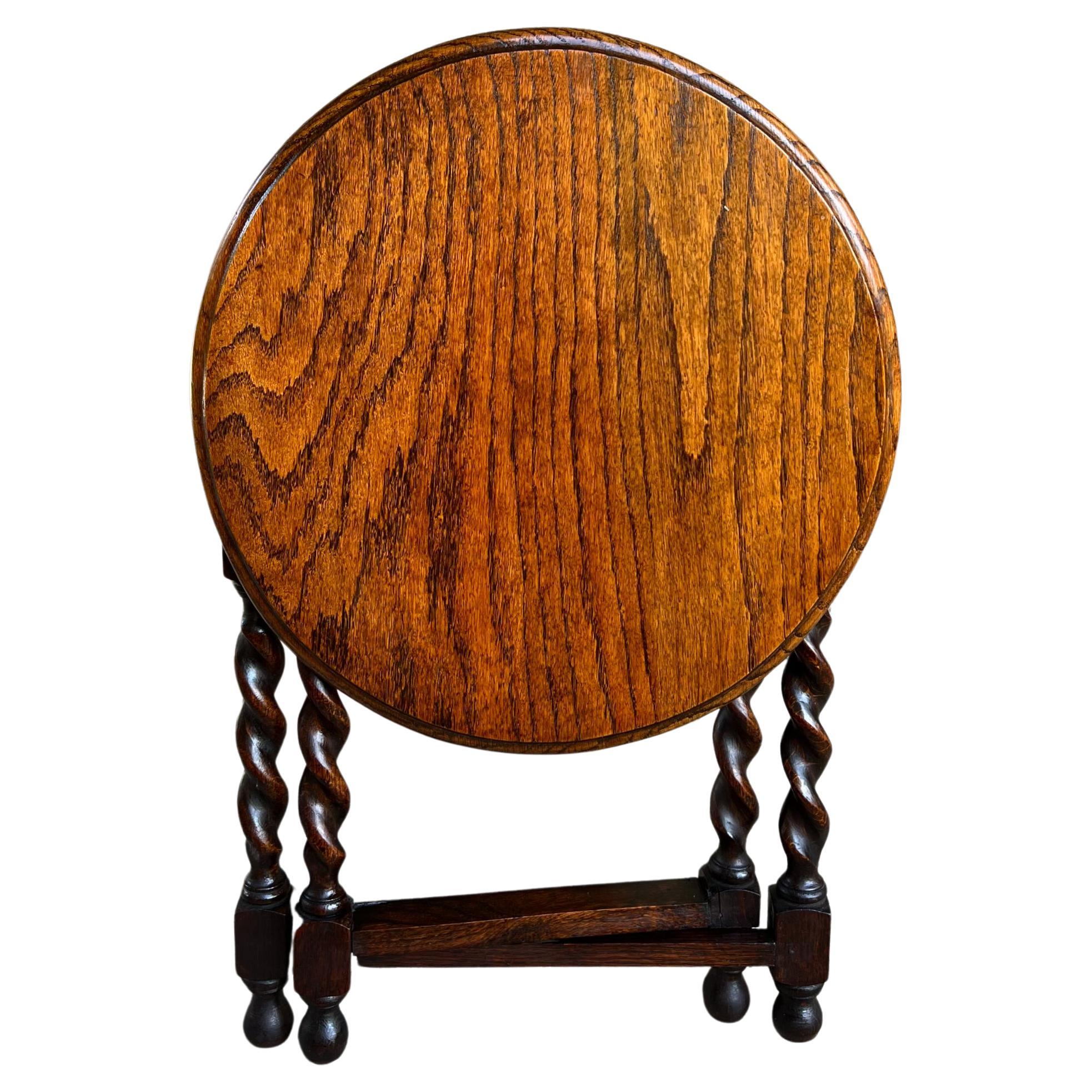 Petite Antique English Tiger Oak Barley Twist round folding tea table gateleg.

Direct from England, a charming antique English oak folding “tea” table.
Features include a small tiger oak round top with beveled edge, and folding base with