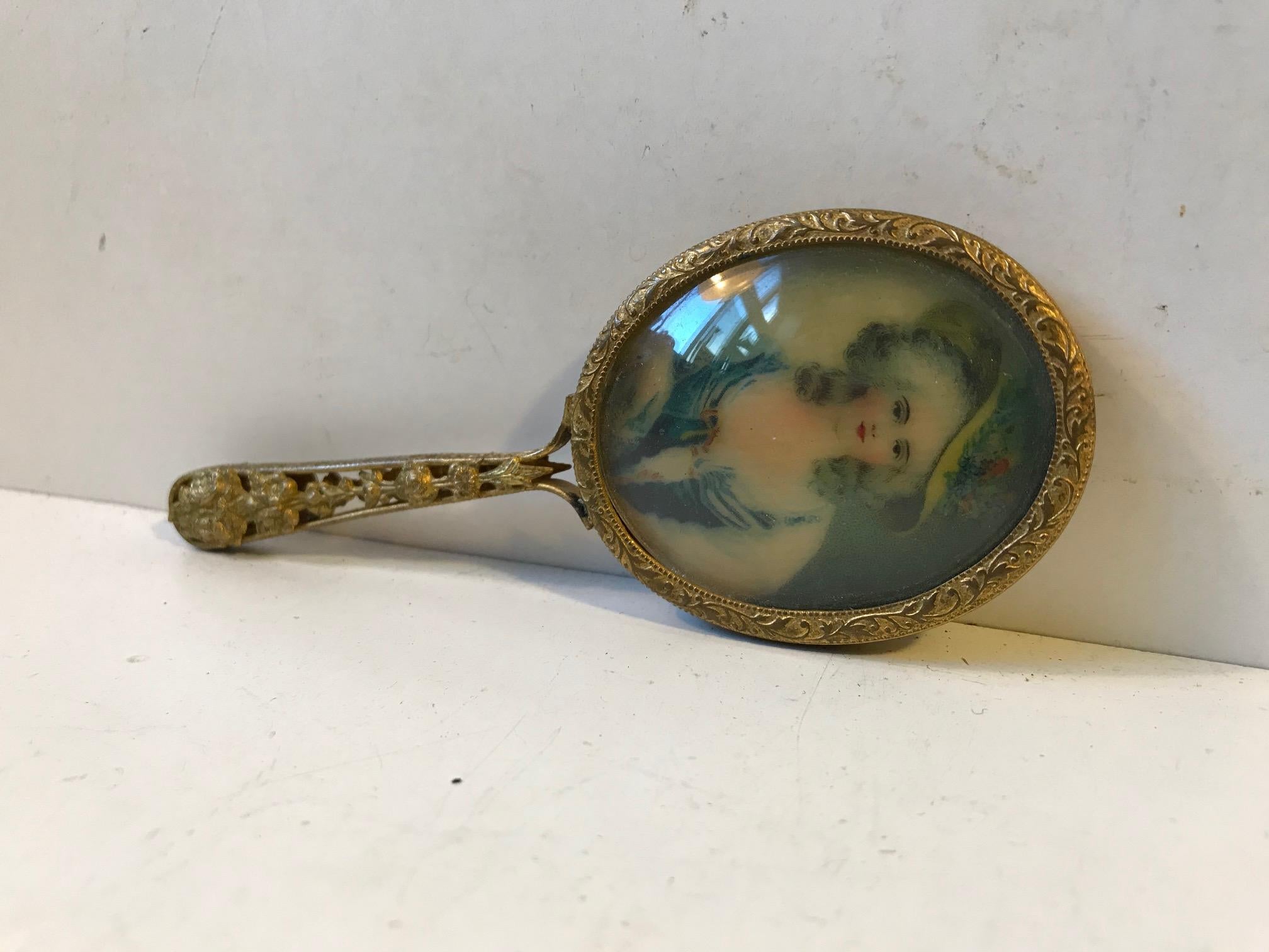 Small French miniature hand mirror in gilded brass/bronze. A beveled mirror to one side and a miniature female portrait behind convex glass to the other.