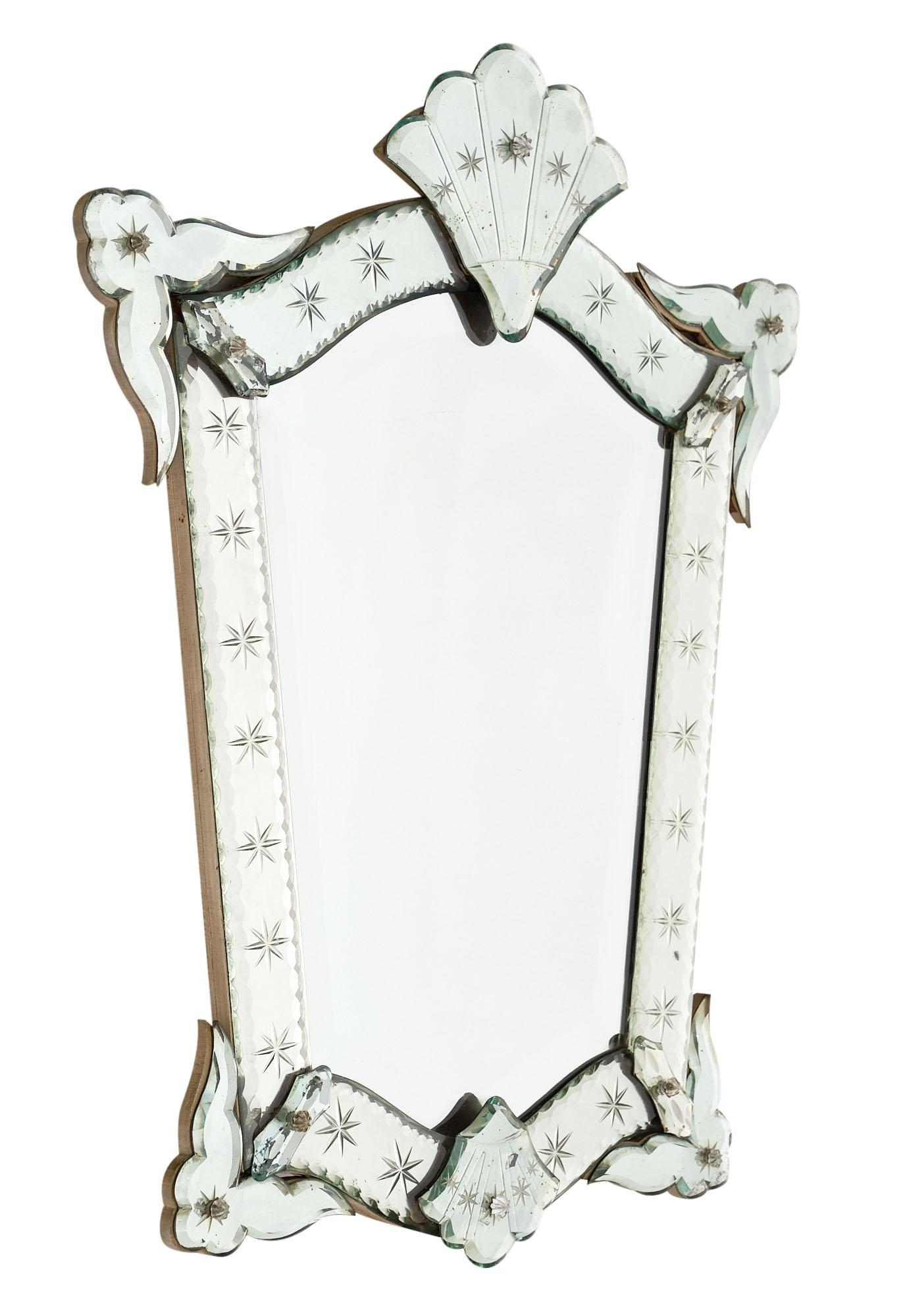 Petite antique Venetian mirror in pristine antique condition. We love the decor of stars engraves on the frame and the scalloped fronton.