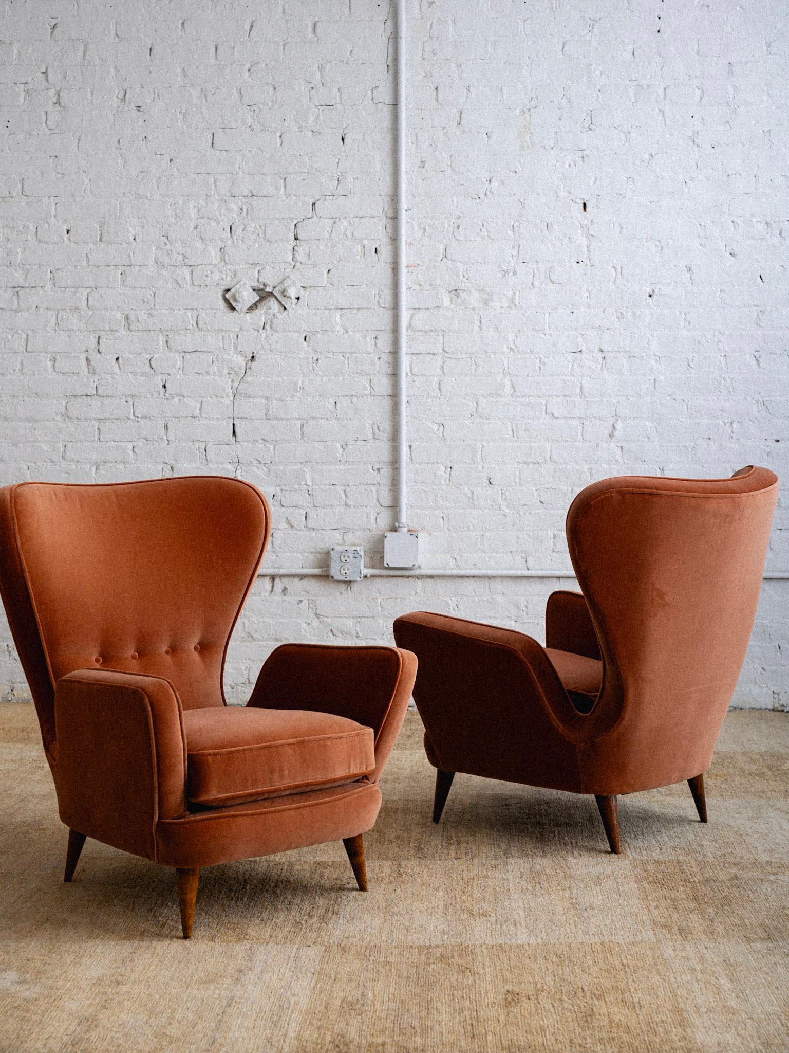 A pair of petite armchairs designed by Emilio Sala and Giorgio Madini and manufactured by Fratelli Galimberti. Wingback style silhouette. Newly upholstered in a salmon colored velvet. Sourced in Northern Italy. 