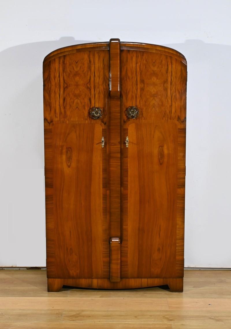 This small English walnut armoire, designed and created by Walrose at the end of the Art Deco era in 1940, is a true masterpiece of design and functionality.
It stands out for its elegant lines and richly grained walnut wood.
The armoire opens with