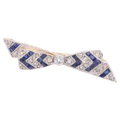 Petite broche Art déco des années 1930 en platine, or 18 carats, saphirs et diamants stylisés