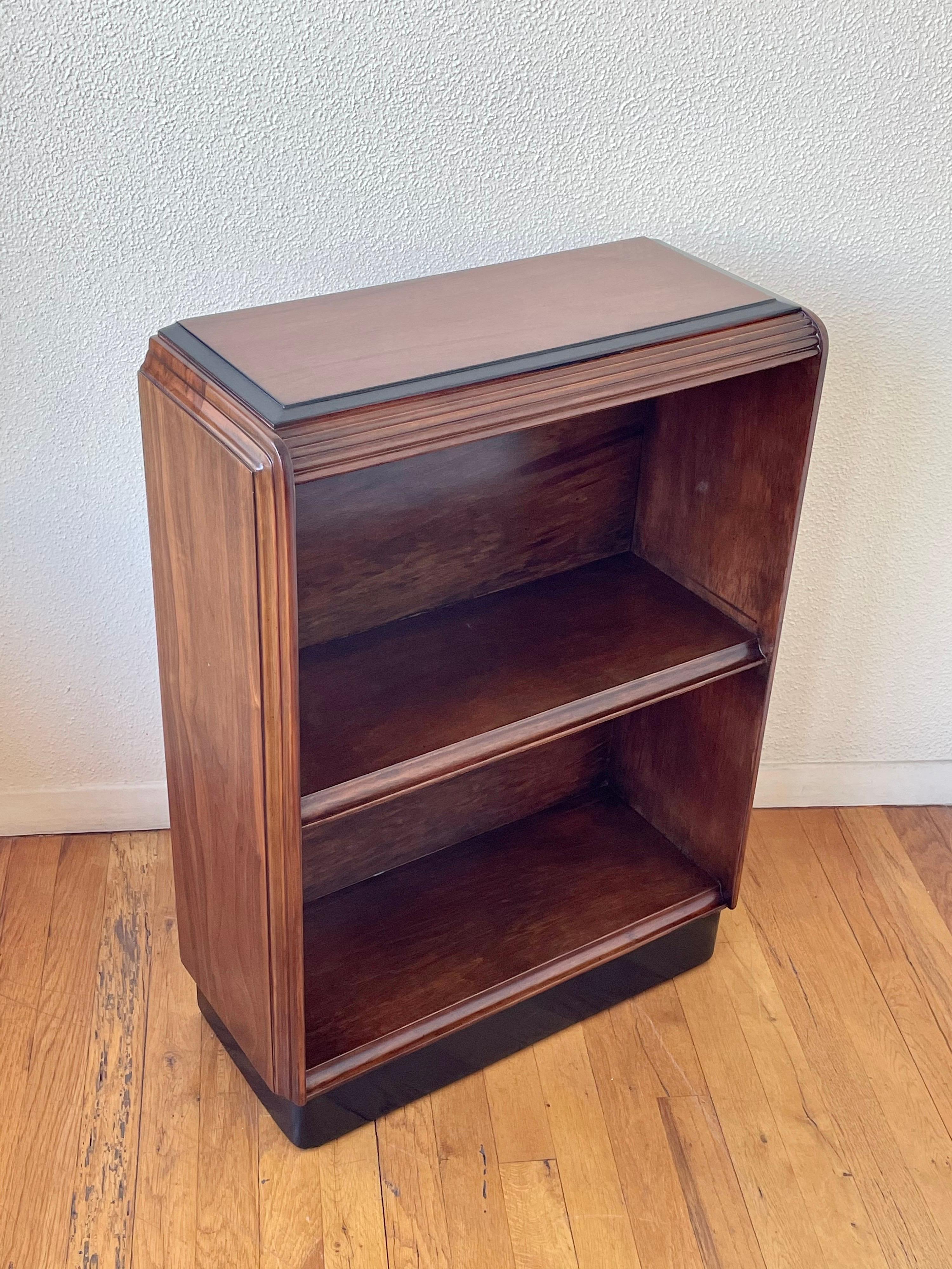 Freshly refinished versatile and practical small Art Deco bookcase, circa 1940s with black trim accents great condition mahogany wood in walnut finish, measures: 12