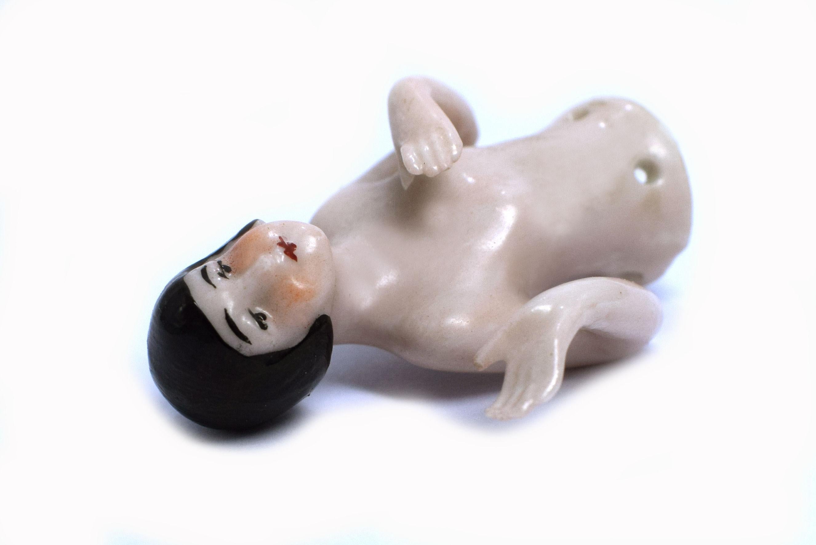 Very delicate and petite Art Deco flapper girl, half nude with black bob hair cut without stretched arms. An unusual size and beautifully detailing in her figuratively and paint wise. Made from Porcelain and originating from Germany it's a wonder